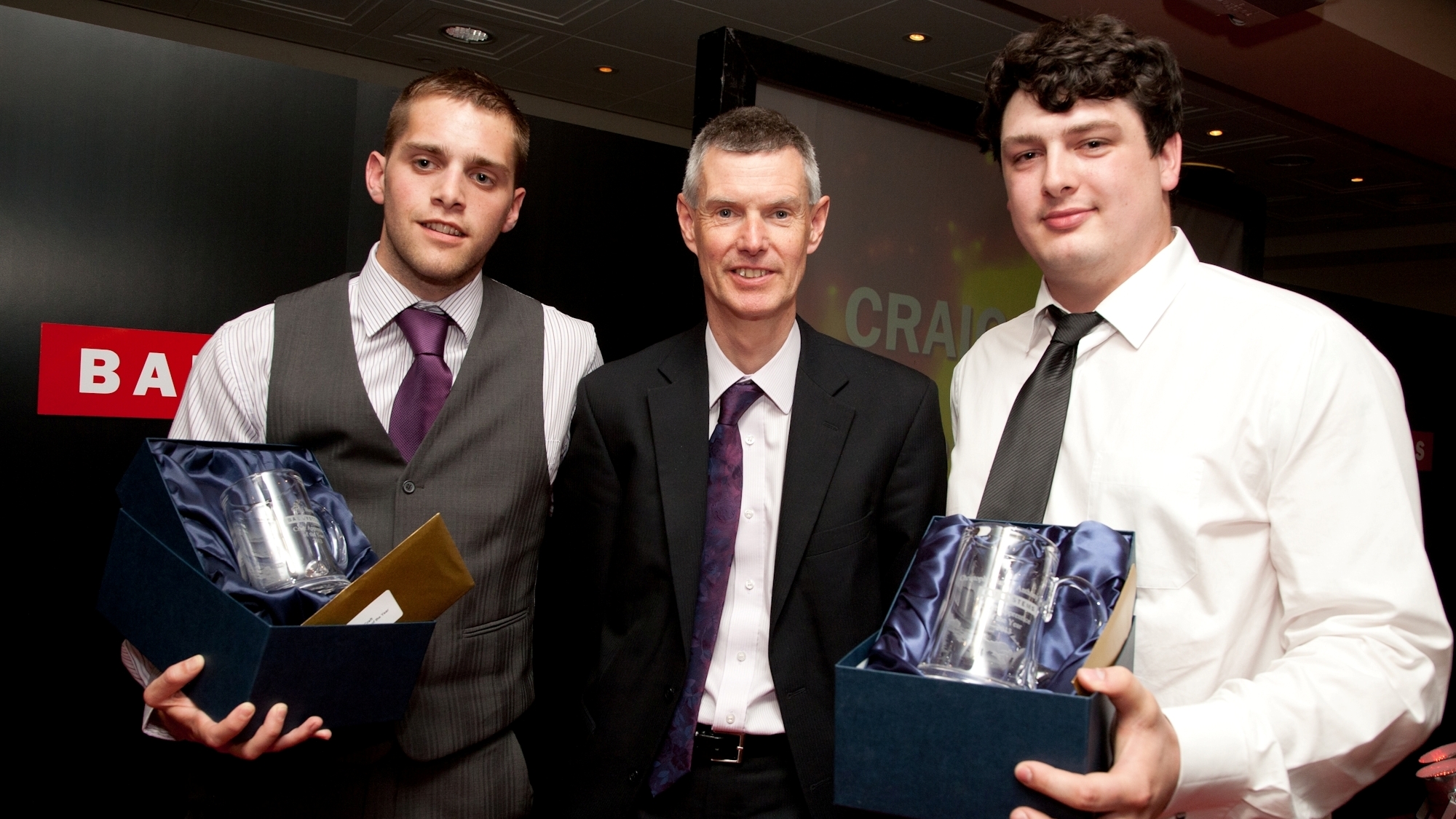 John Hudson, MD, presents award to joint winners, Craig (left) and Christopher
