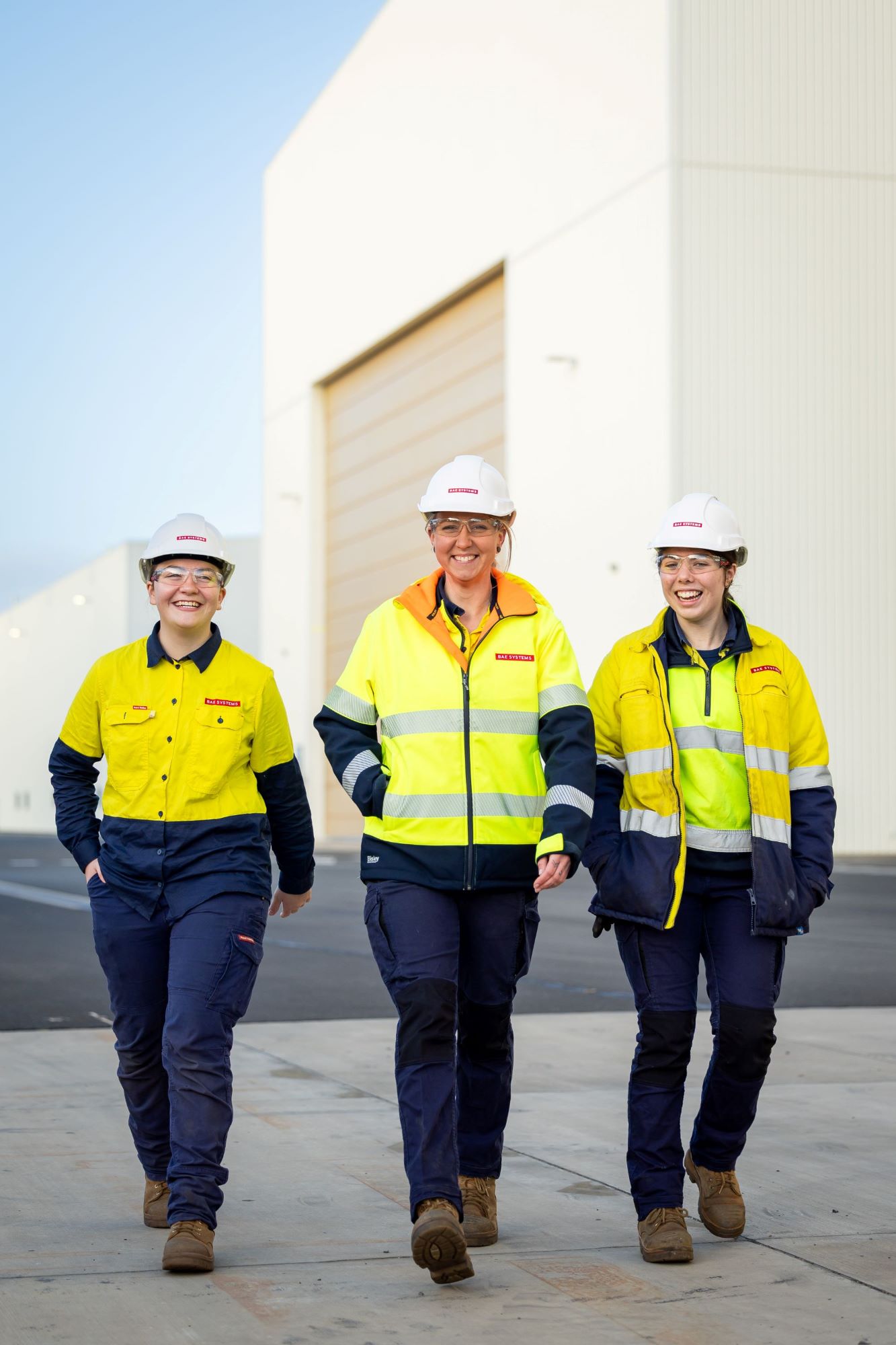 Apprentices Becky, Lexi & Mel walking through the Osborne Naval Shipyard, smiling & laughing