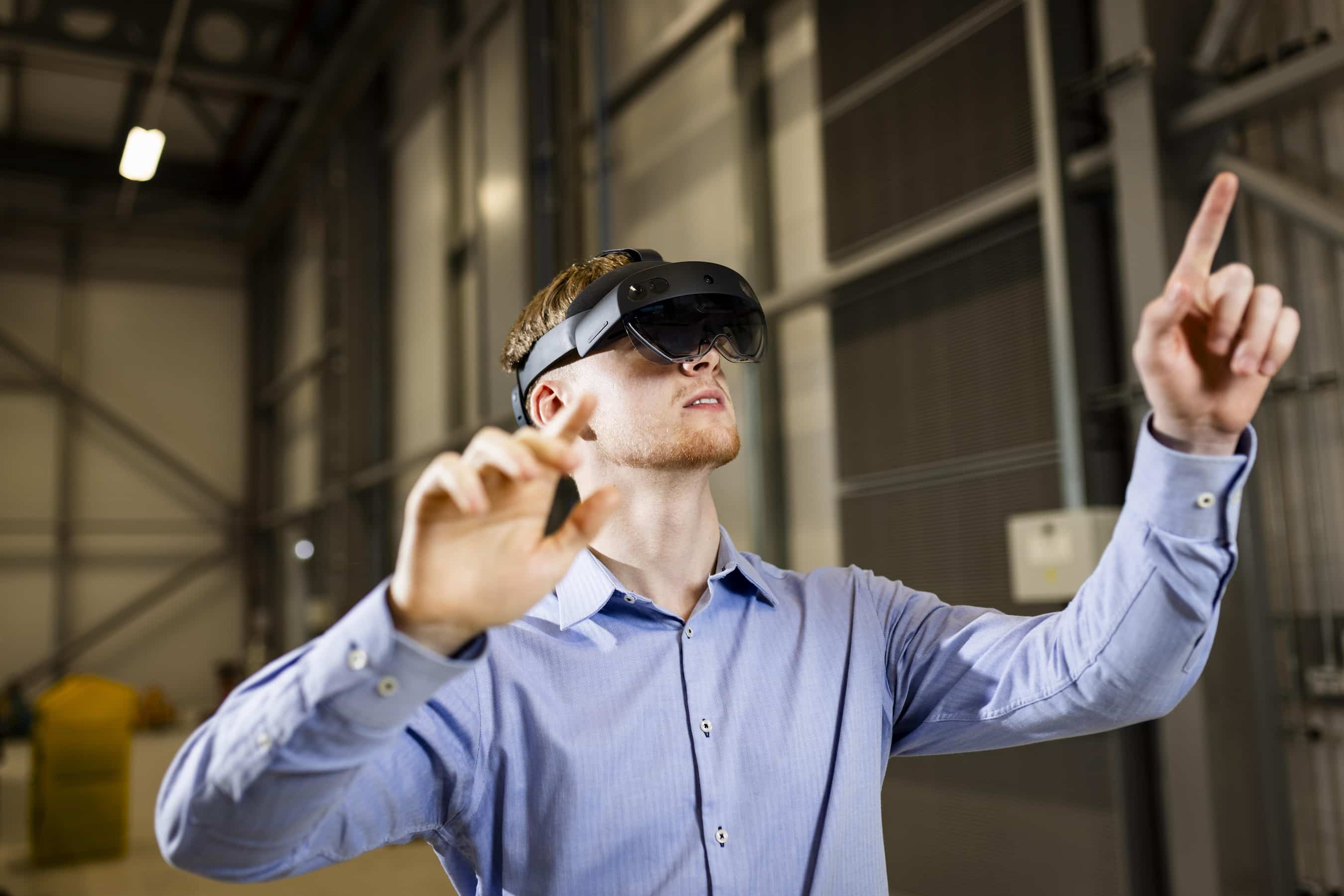 Young man wearing VR headset pointing at an unseen interface