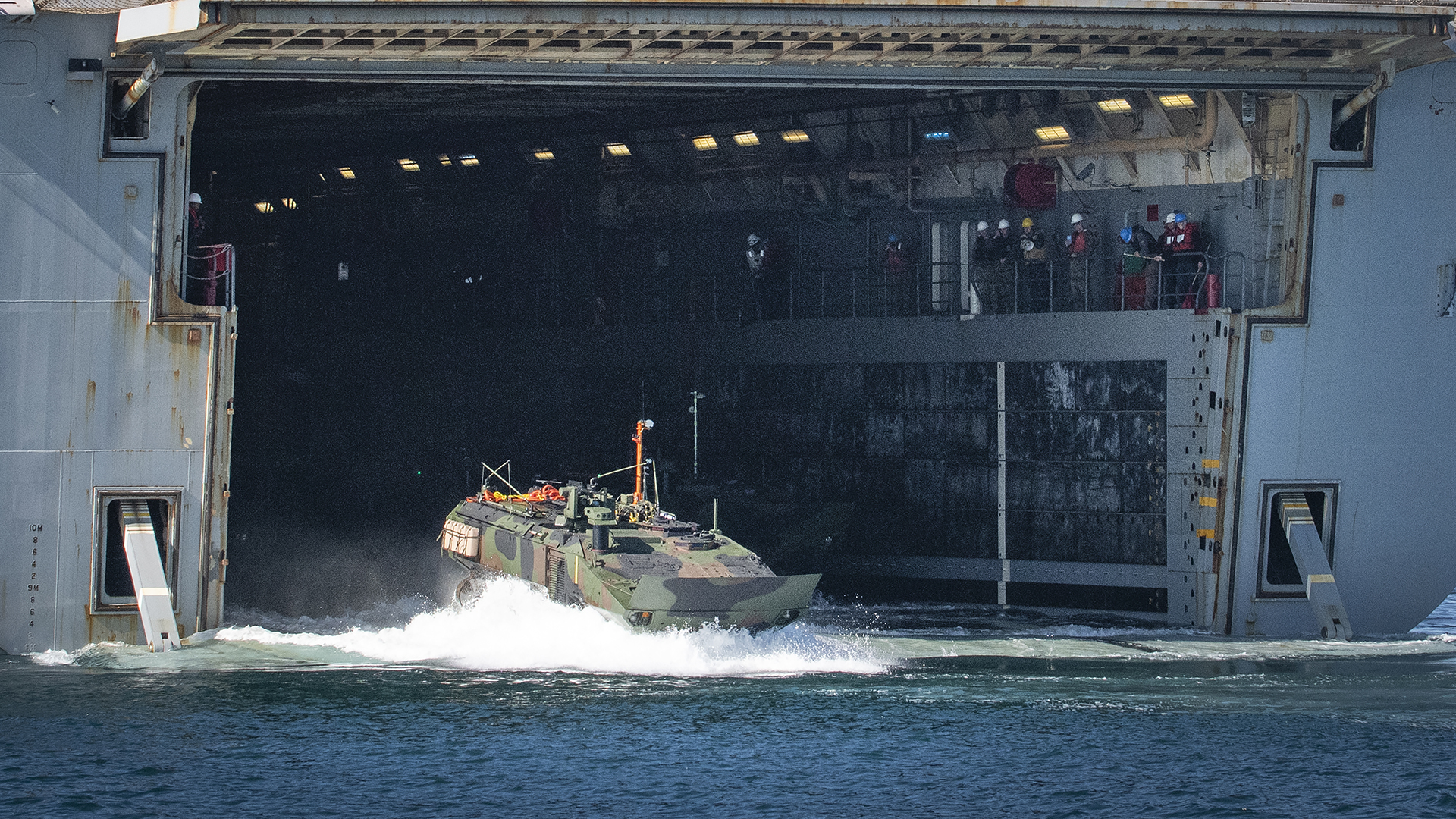 An Amphibious Combat Vehicle disembarks a large naval ship during swim testing in the Pacific Ocean. 