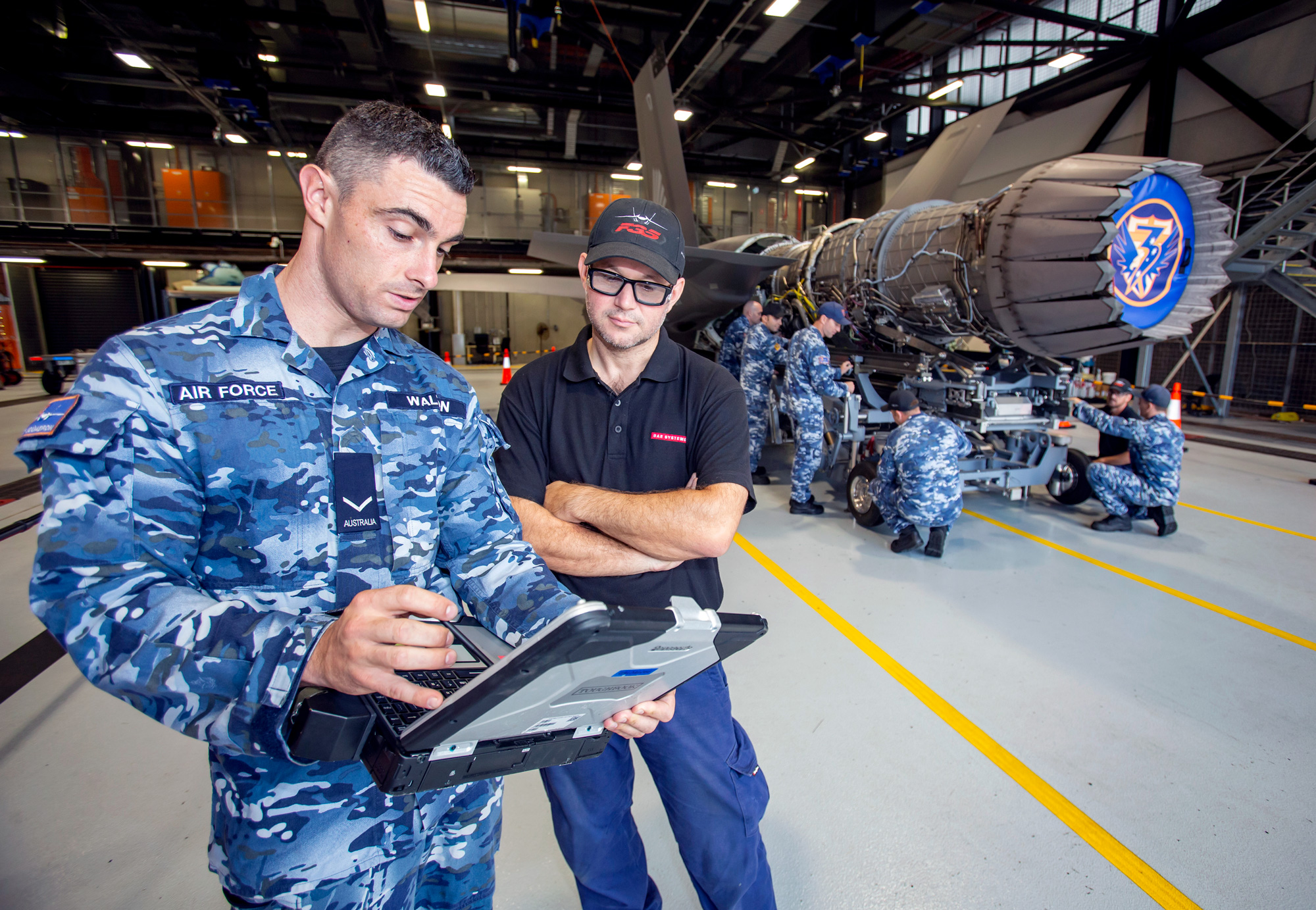 Aircraft Technician, Leading Aircraftman Adam Walton from No. 3 Squadron and BAE Systems Technician, Jody refer to the technical publications while removing a Pratt and Whitney F135 Engine from aircraft A35-017 at RAAF Base Williamtown.