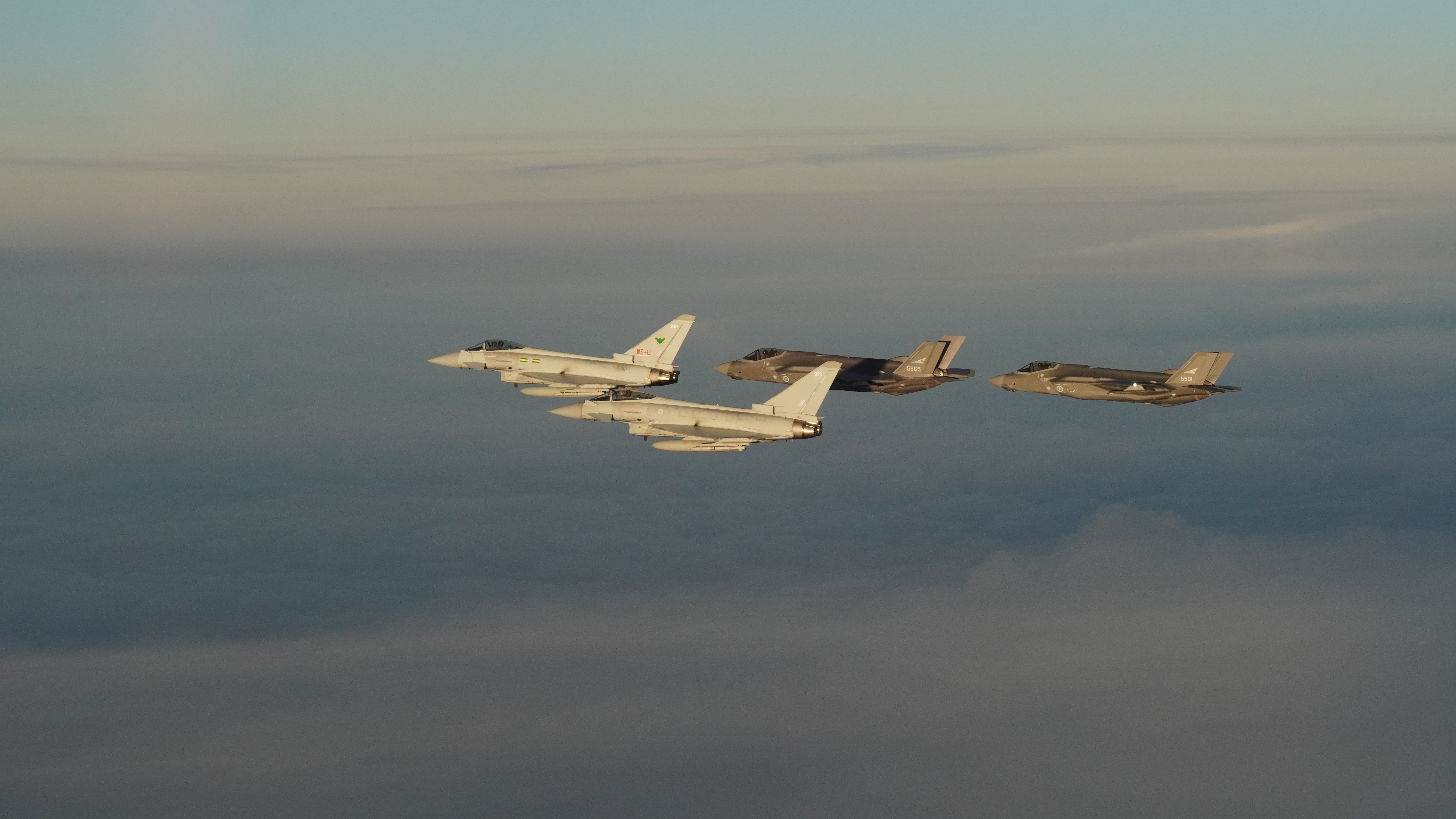 Eurofighter Typhoon aircraft from the RAF fly alongside F-35As of the RNoAF