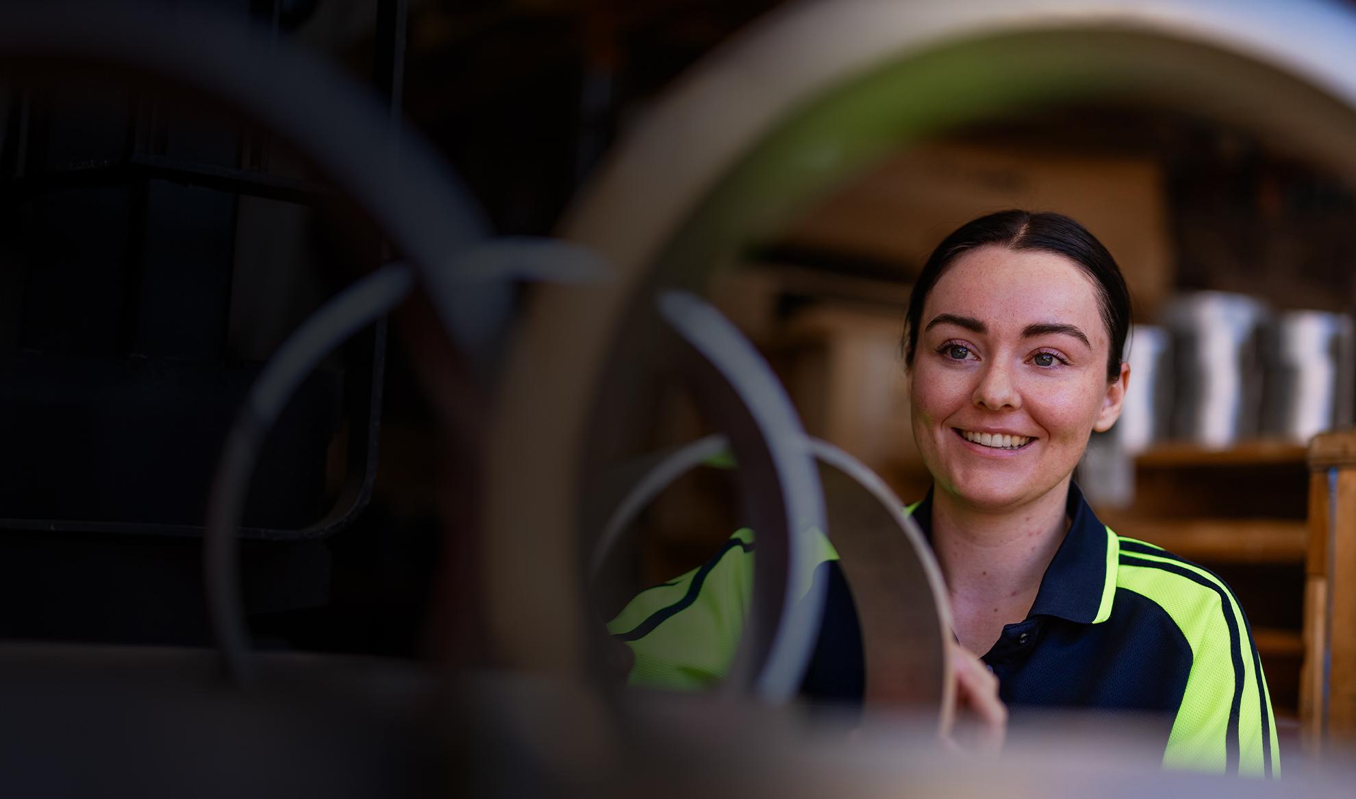 Female looking through metal pipes
