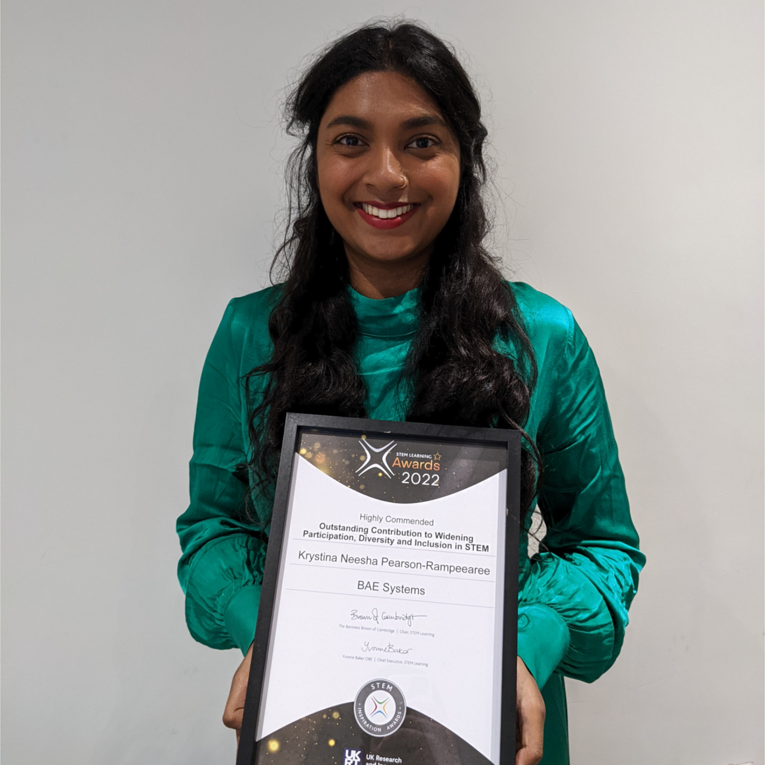 Krystina holding her award certificate