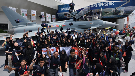 Students of MIGHT's school outreach program pose in front of a Typhoon replica