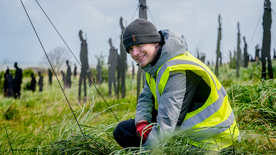 A volunteer poses for a photo at the Standing with Giants installation between Gold Beach and the British Normandy Memorial in Ver-sur-Mer, France.