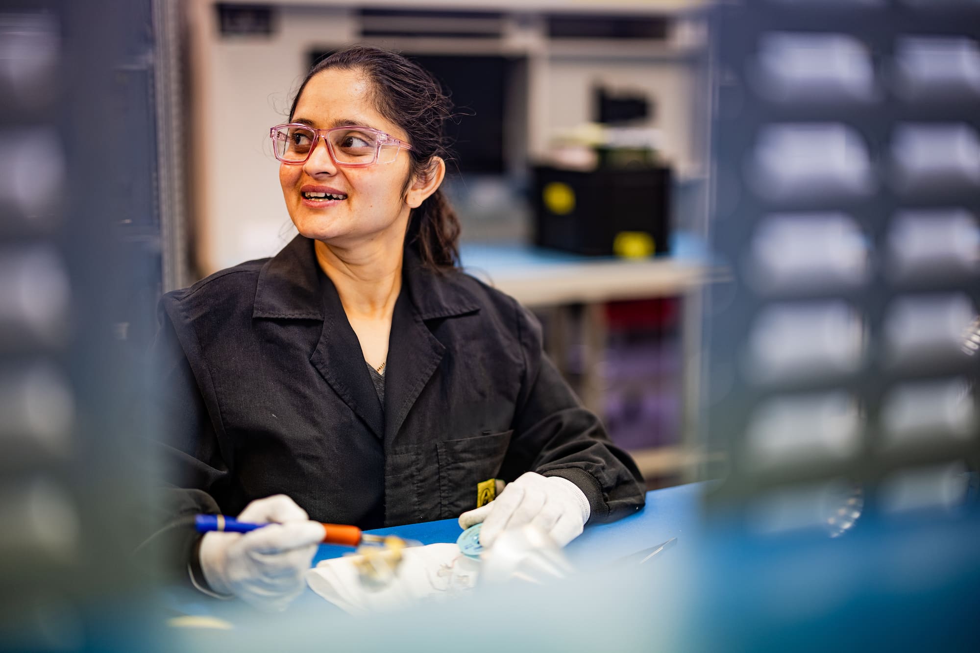 Employee wearing protective eyegear at workbench