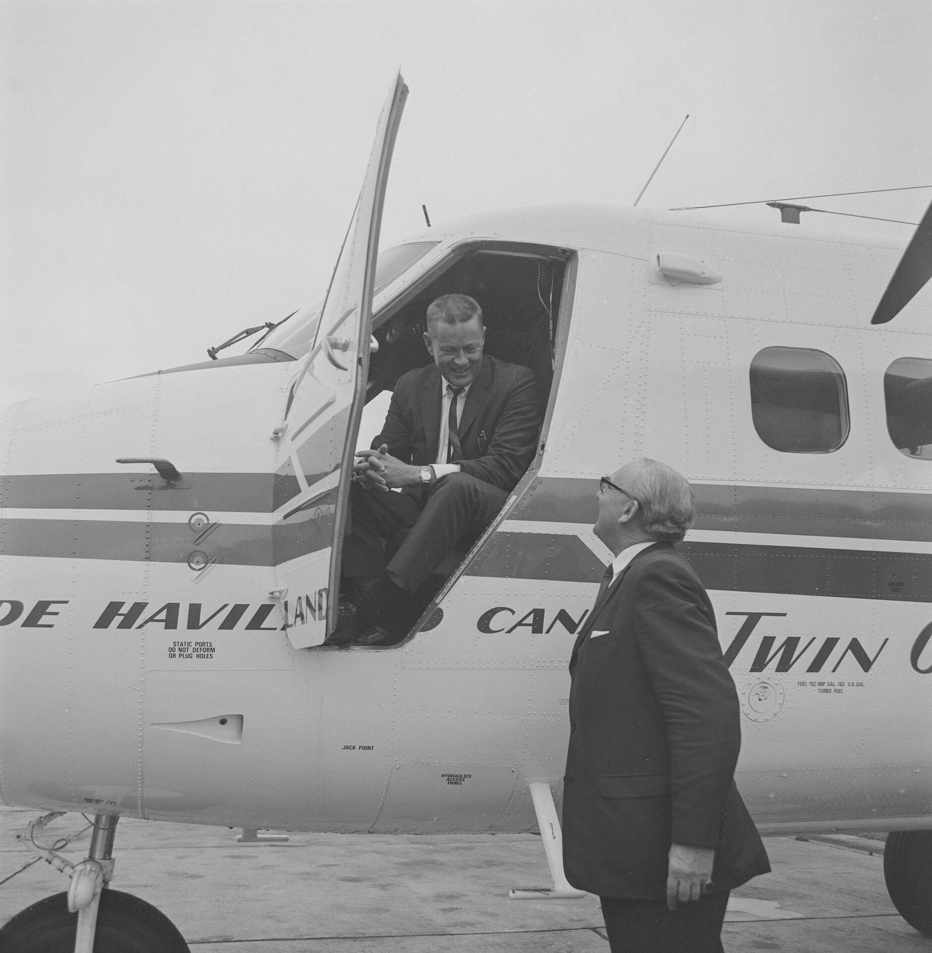 A man leaning out of the cockpit of a de Havilland Canada DHC-6 Twin Otter, speaking to another man, at a demonstration of the aircraft at Hatfield, 26th September 1968. Neg DH 16474A