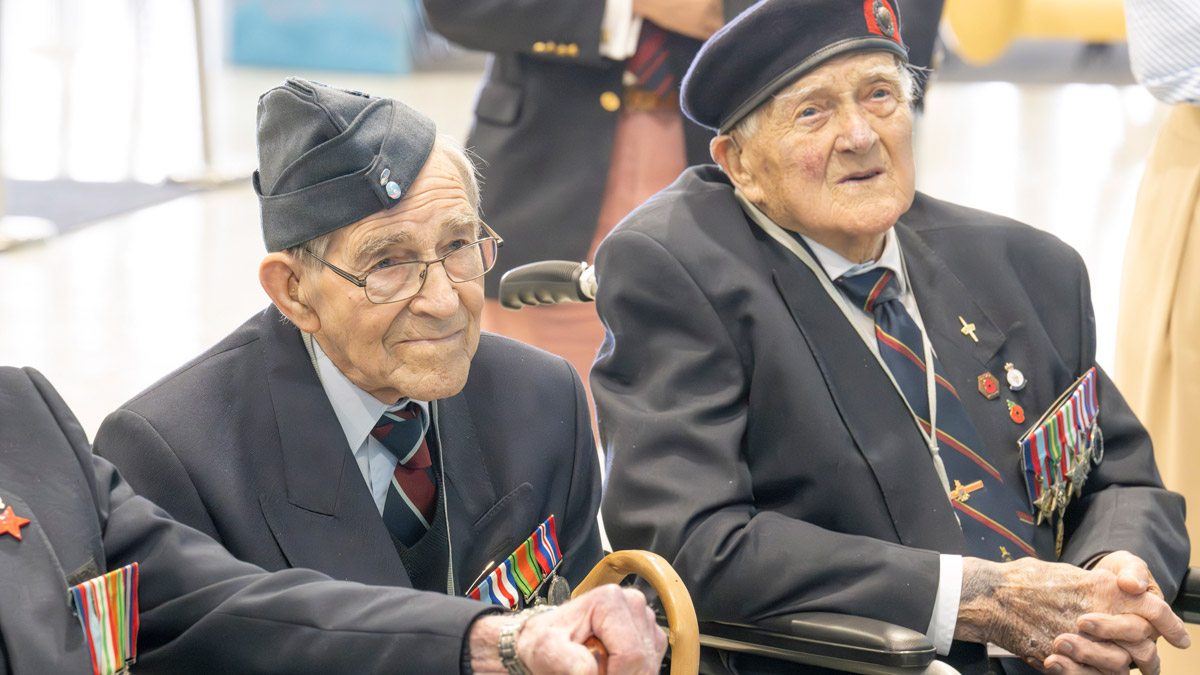 Two volunteers pose for a photo at the Standing with Giants installation between Gold Beach and the British Normandy Memorial in Ver-sur-Mer, France.