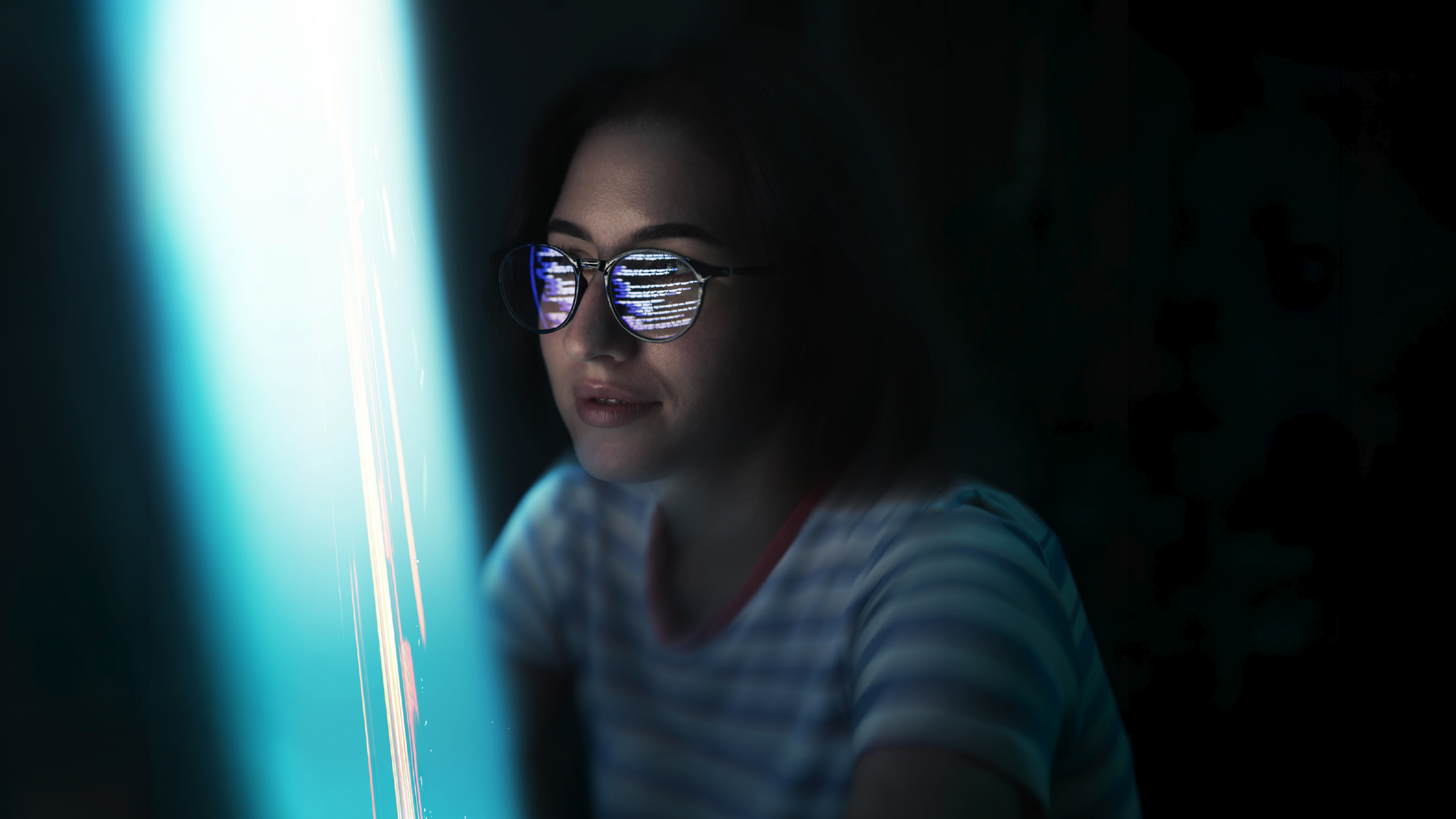 person wearing glasses reflecting lines of code