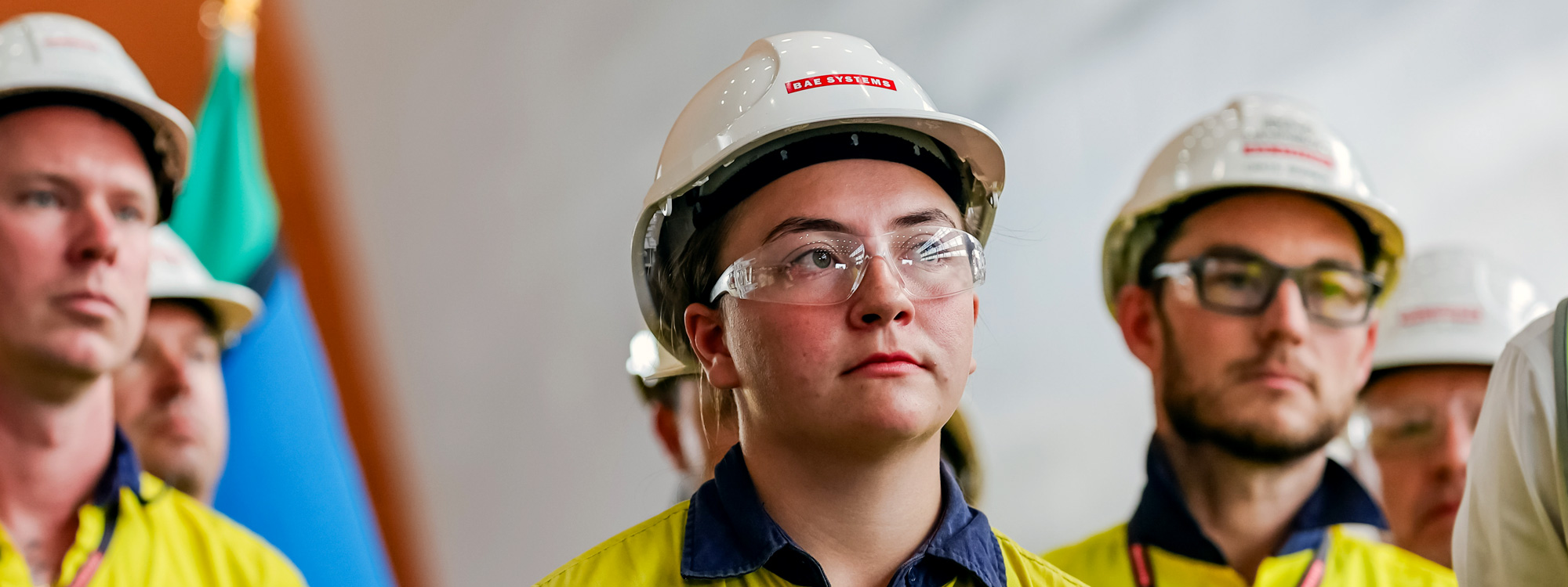 Close up of shipbuilders at Osborne Naval Shipyard wearing glasses and helmets