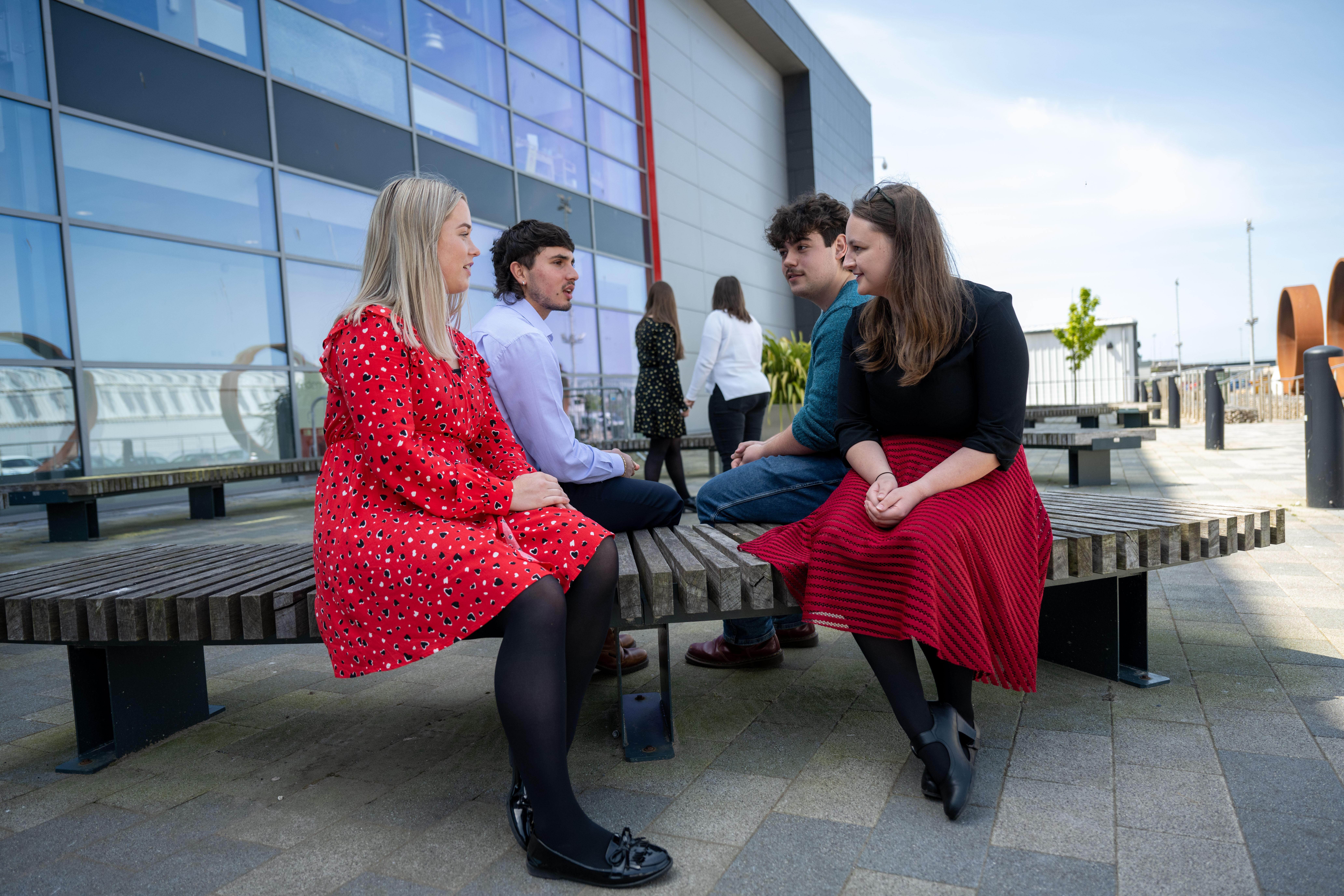 Group of young colleagues sitting outside the office in the sunshine