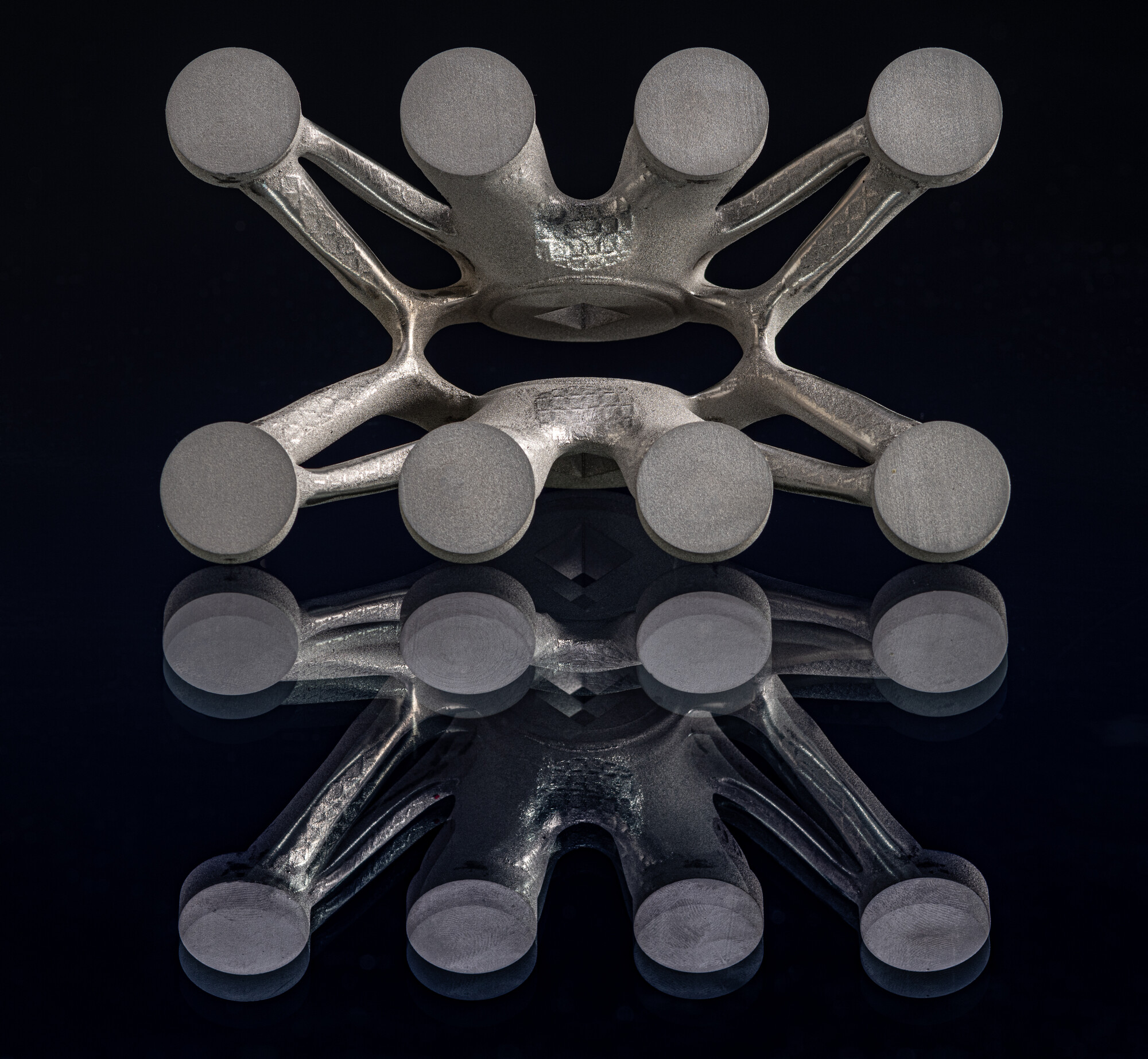 3D printed bracket from underneath with reflection on black surface