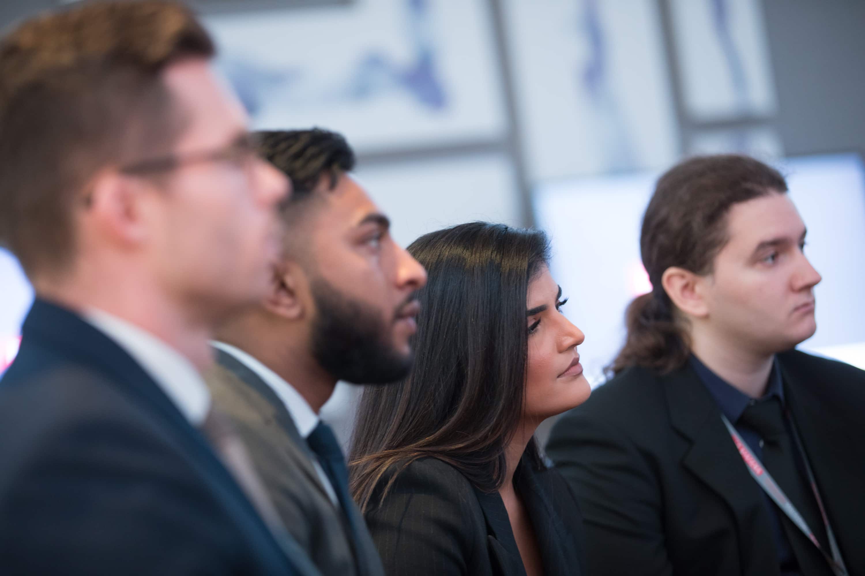 Young people in smart businesswear listening intently to a talk