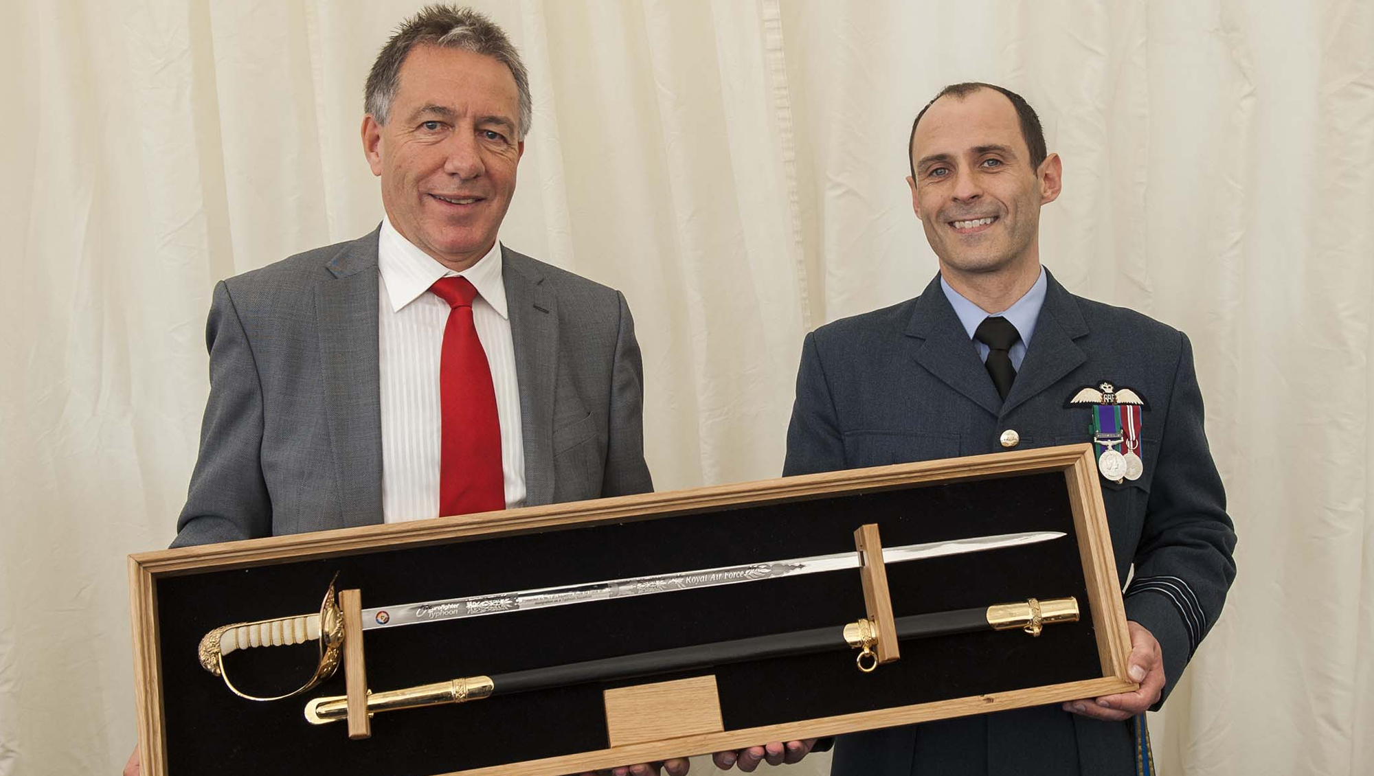 Joe Parker, Eurofighter Export Director hands over the honorary squadron sword to Wing Commander Mark Flewing