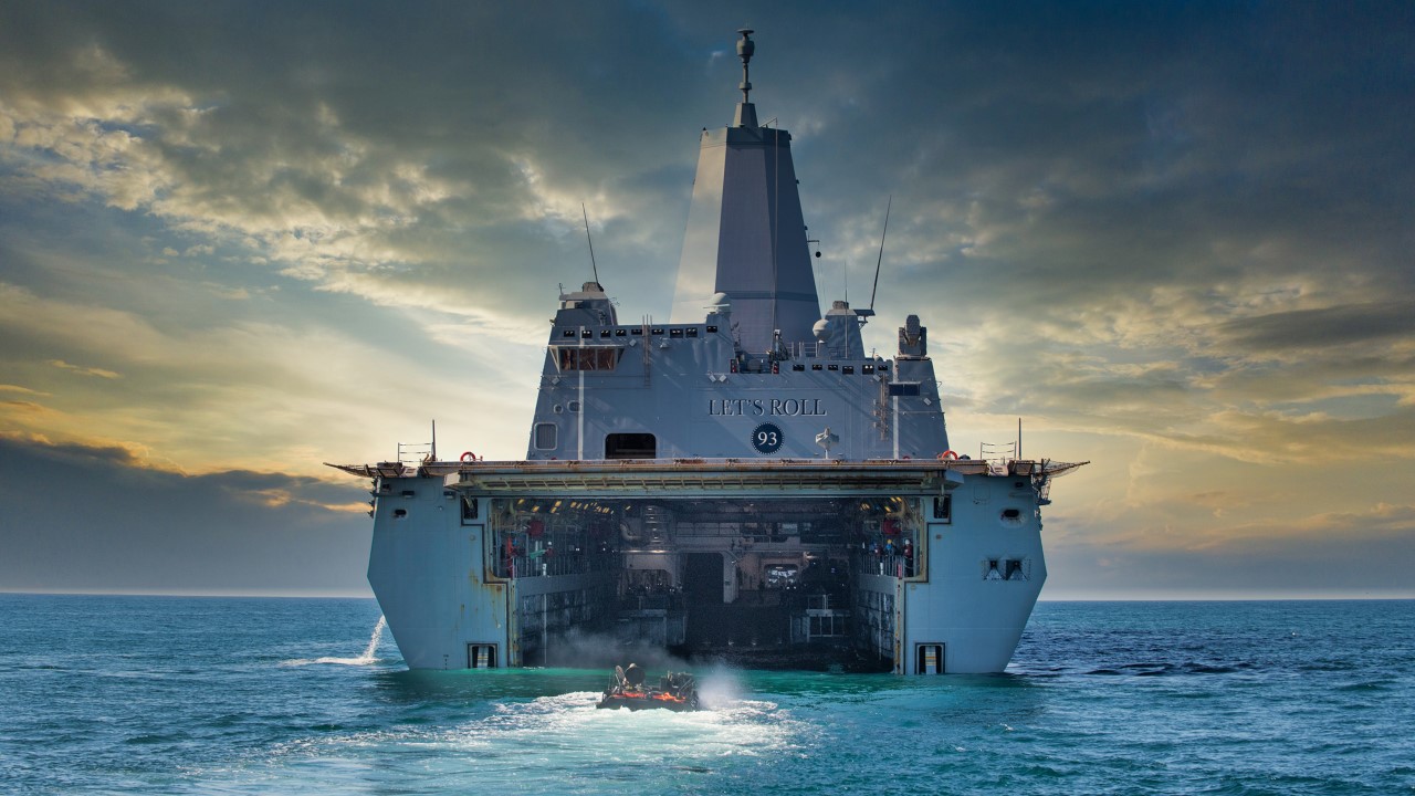 An Amphibious Combat Vehicle embarks a large naval ship during swim testing in the Pacific Ocean.