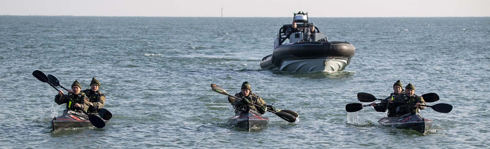 Cockleshell 22 group in kayaks with Stormblade in background