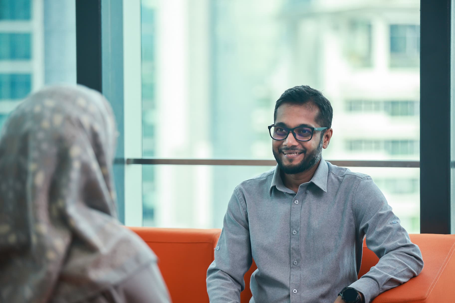 Two employees talking in front of a window
