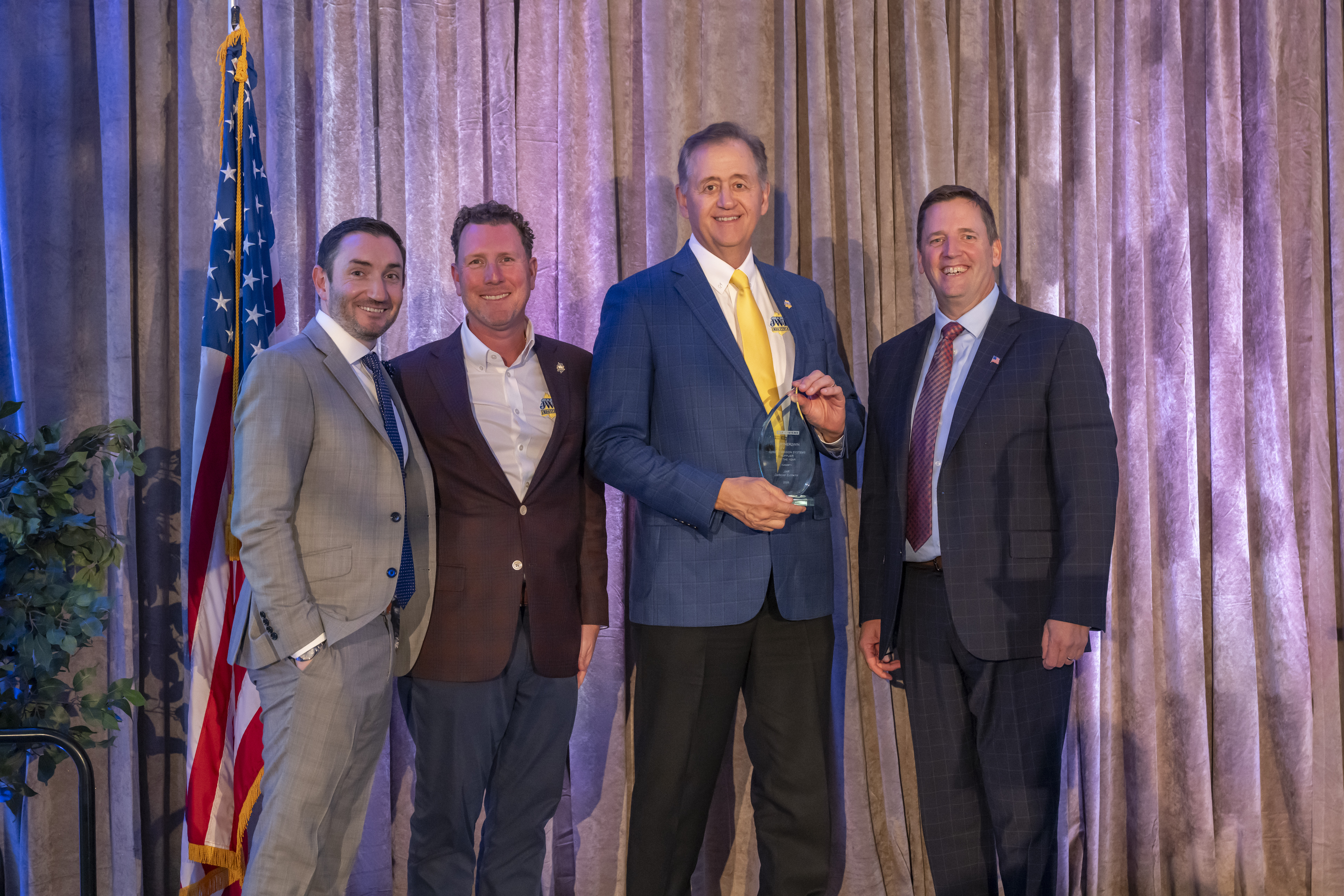 Andy Corea, vice president and general manager of CMS and Garrett Lacaillade, vice president of Integrated Operations present representatives from JWF Defense Systems with the Supplier of the Year award at the 2026 Partner2Win Supplier symposium on Oct. 27, 2026.