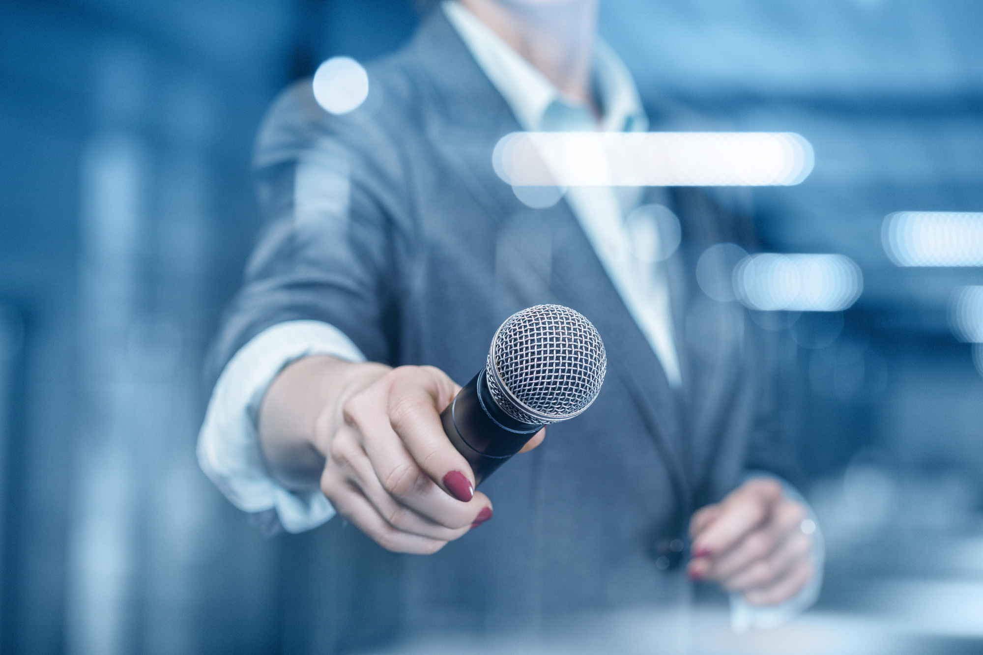 Image of person with a microphone and notepad