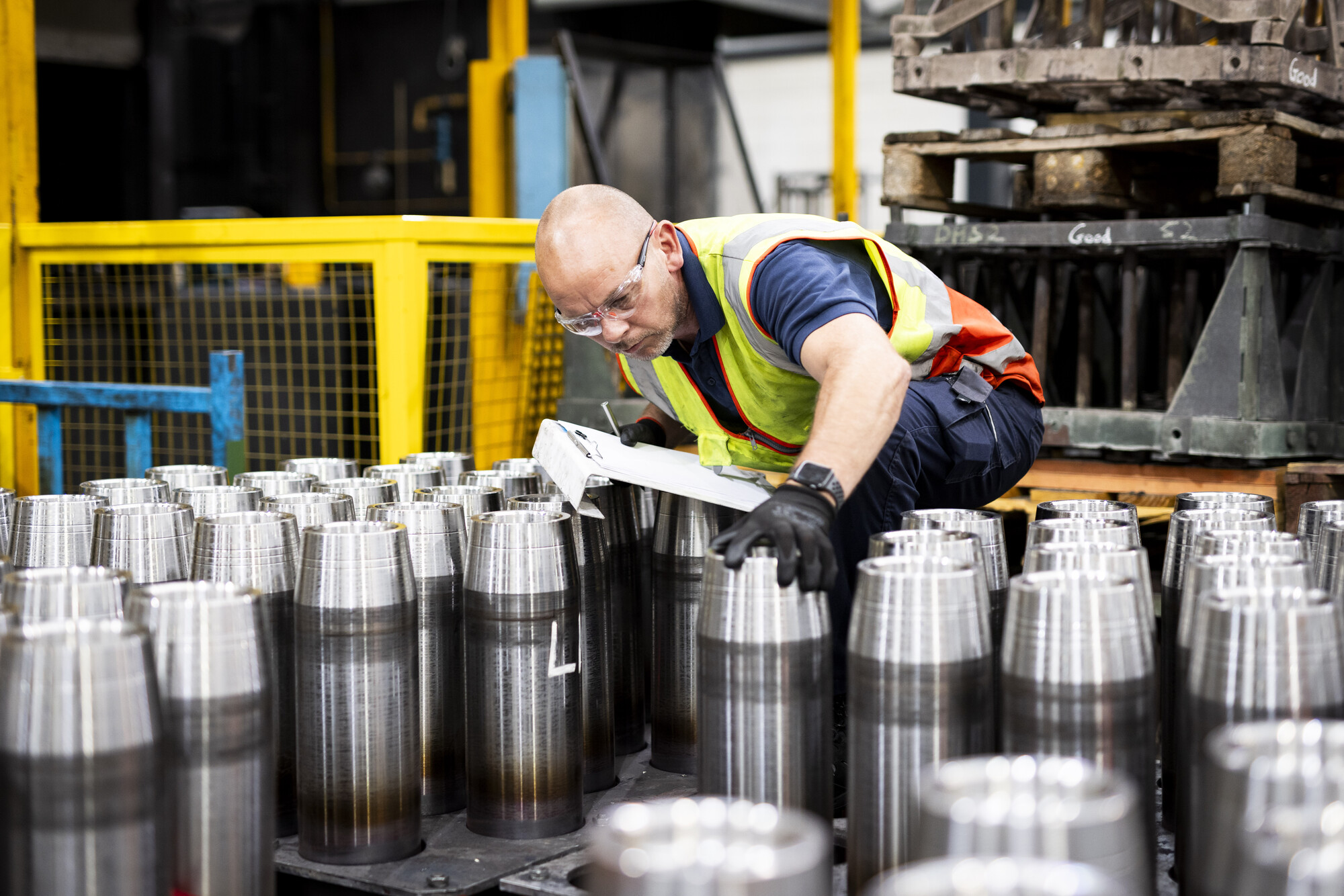 Image of a worker conducting visual inspection of munitions shells