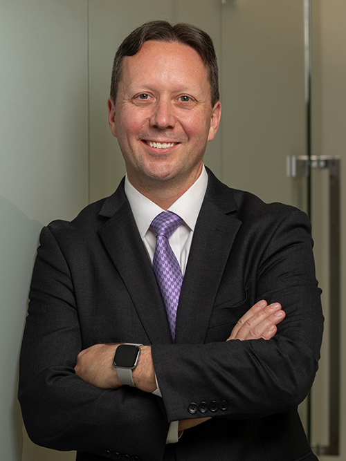 Jeremy Tondreault, president of Platforms & Services, smiles in an office environment with his arms crossed.