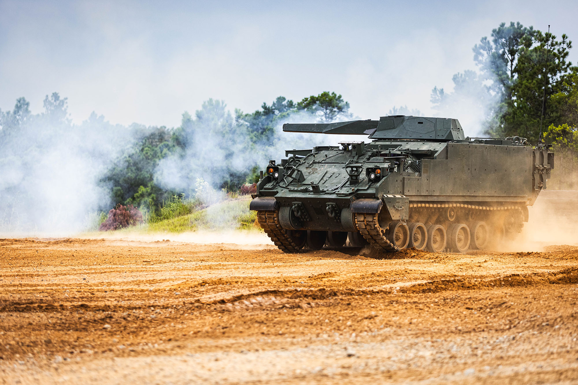 AMPV in a dirt field with smoke around it