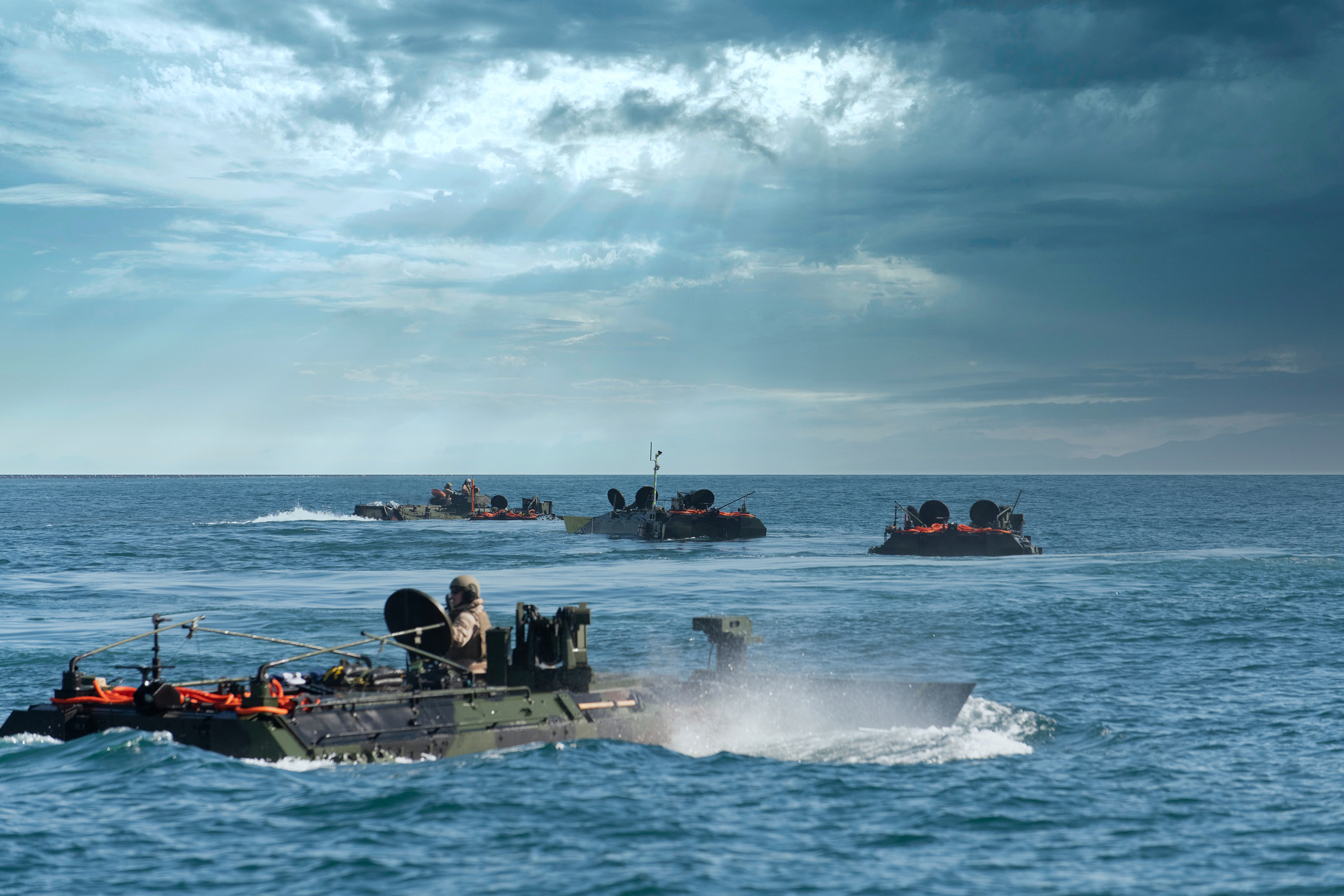 Four Amphibious Combat Vehicles conducting swim operations at United States Marine Corps base in California.