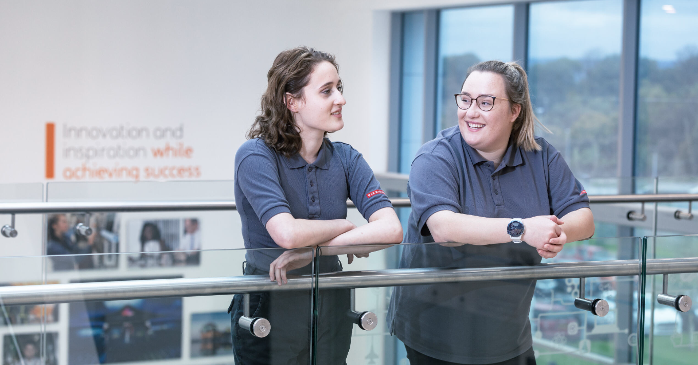 Two engineering employees at BAE Systems have a meeting on a balcony.