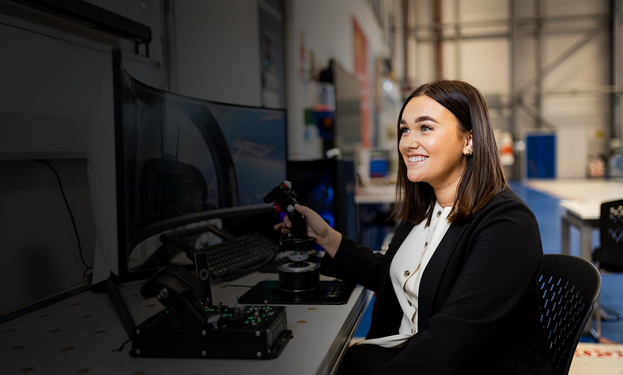 Female sitting at desk using joystick