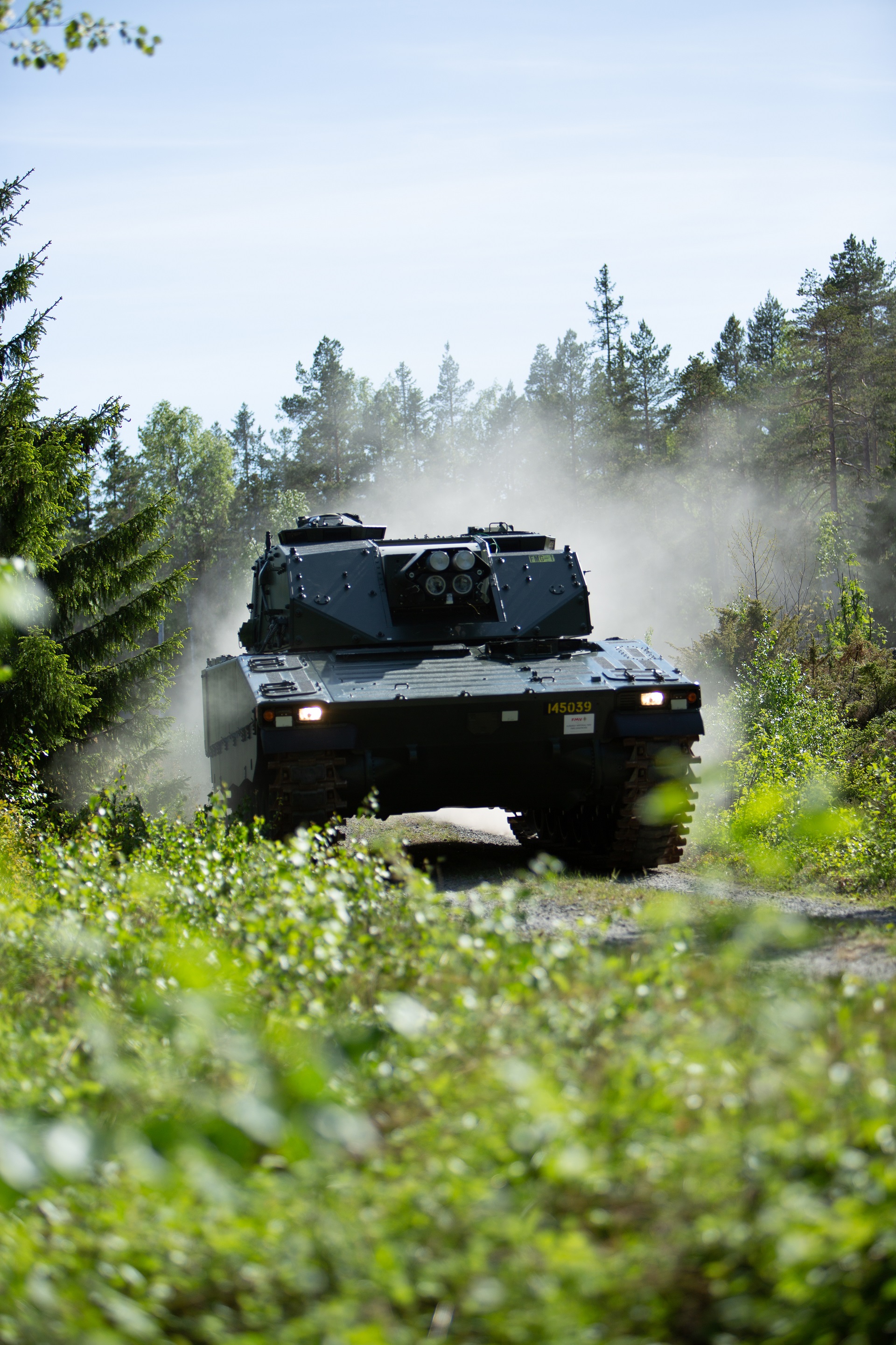 Mjölner driving through a grass field with trees in the background