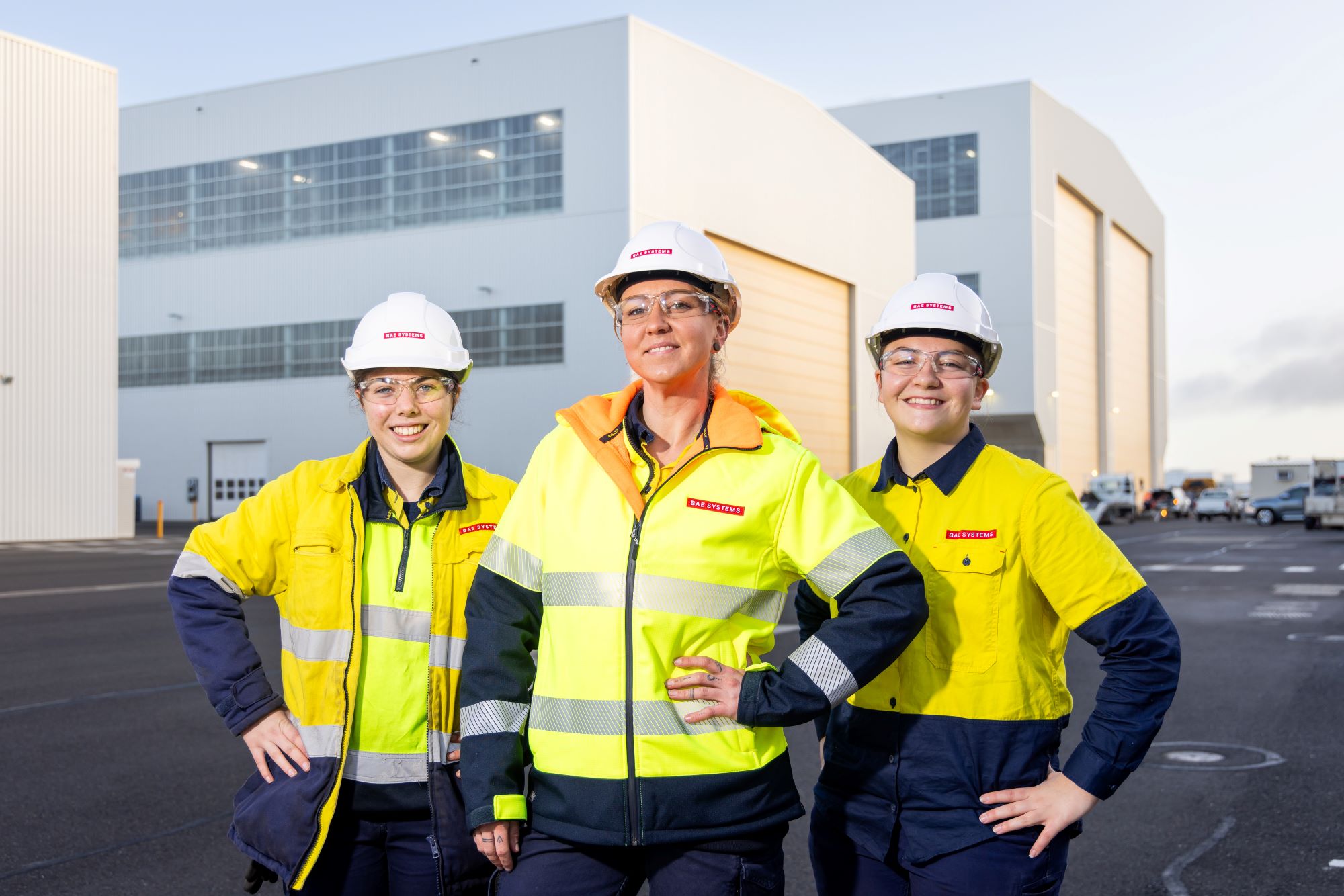 Apprentices Becky, Lexi & Mel posing outside some buildings at the Osborne Naval Shipyard