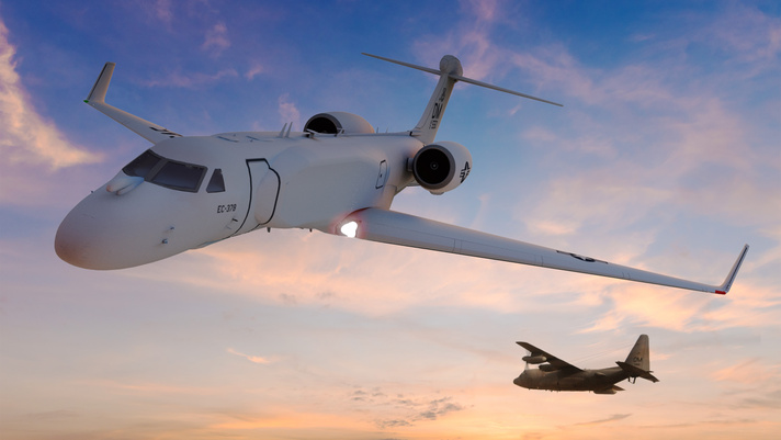 Woman and man standing at edge of fuselage which is now inside a lab at BAE Systems. Two people are talking and smiling