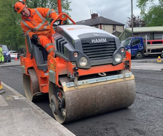 Roller laying runway material on Lancashire road
