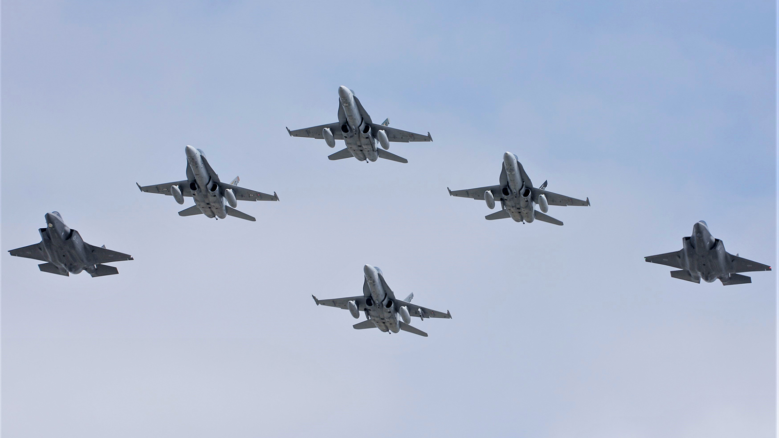 The first F-35 aircraft to arrive at RAAF Base Williamtown in formation with F/A-18 Hornets. Image courtesy Wayne Brown.