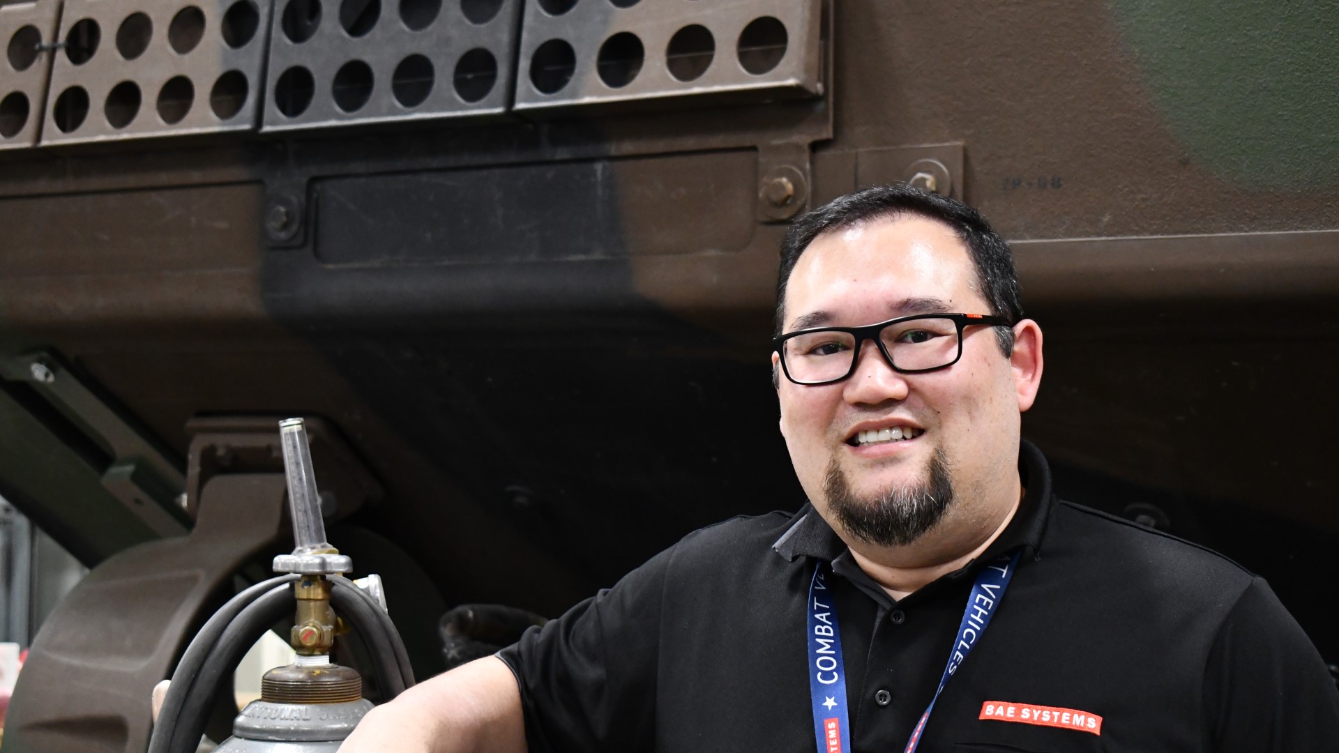 Jesse Swangnete, a senior principal electrical engineer at BAE Systems, standing in front of an Amphibious Combat Vehicle (ACV), in the Vehicle Testing and Integration Lab (VTIL) in San Jose, California.