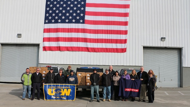 Employees in front of flag