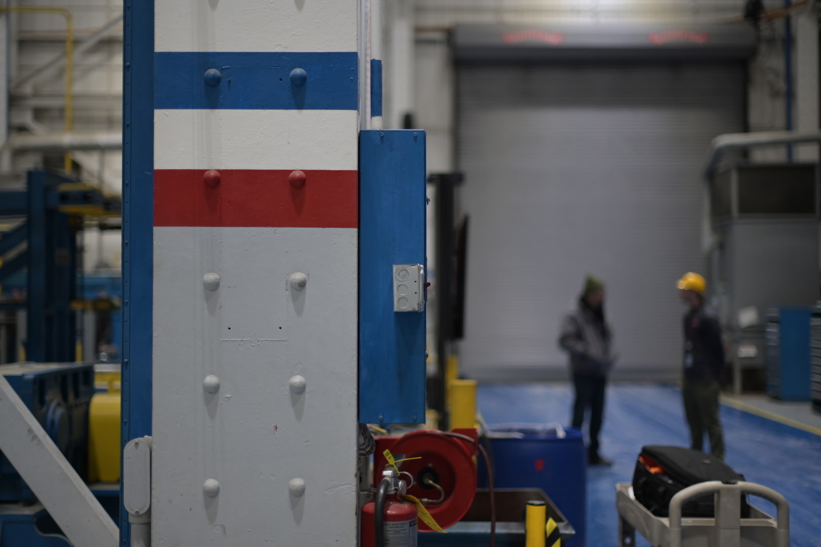 Workers have a discussion inside a large BAE Systems facility