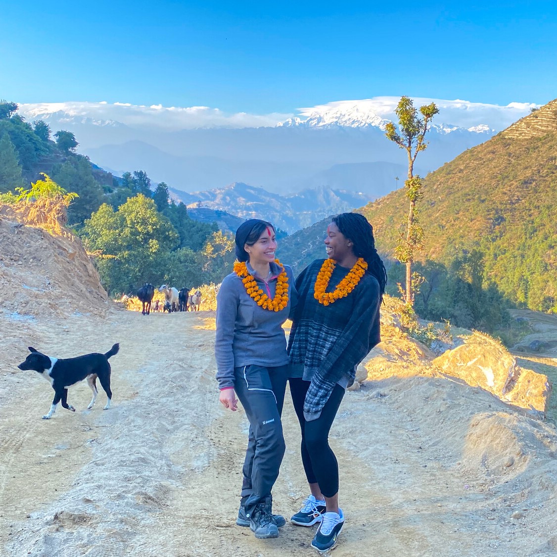 Khadijah and colleague smiling with a mountain view