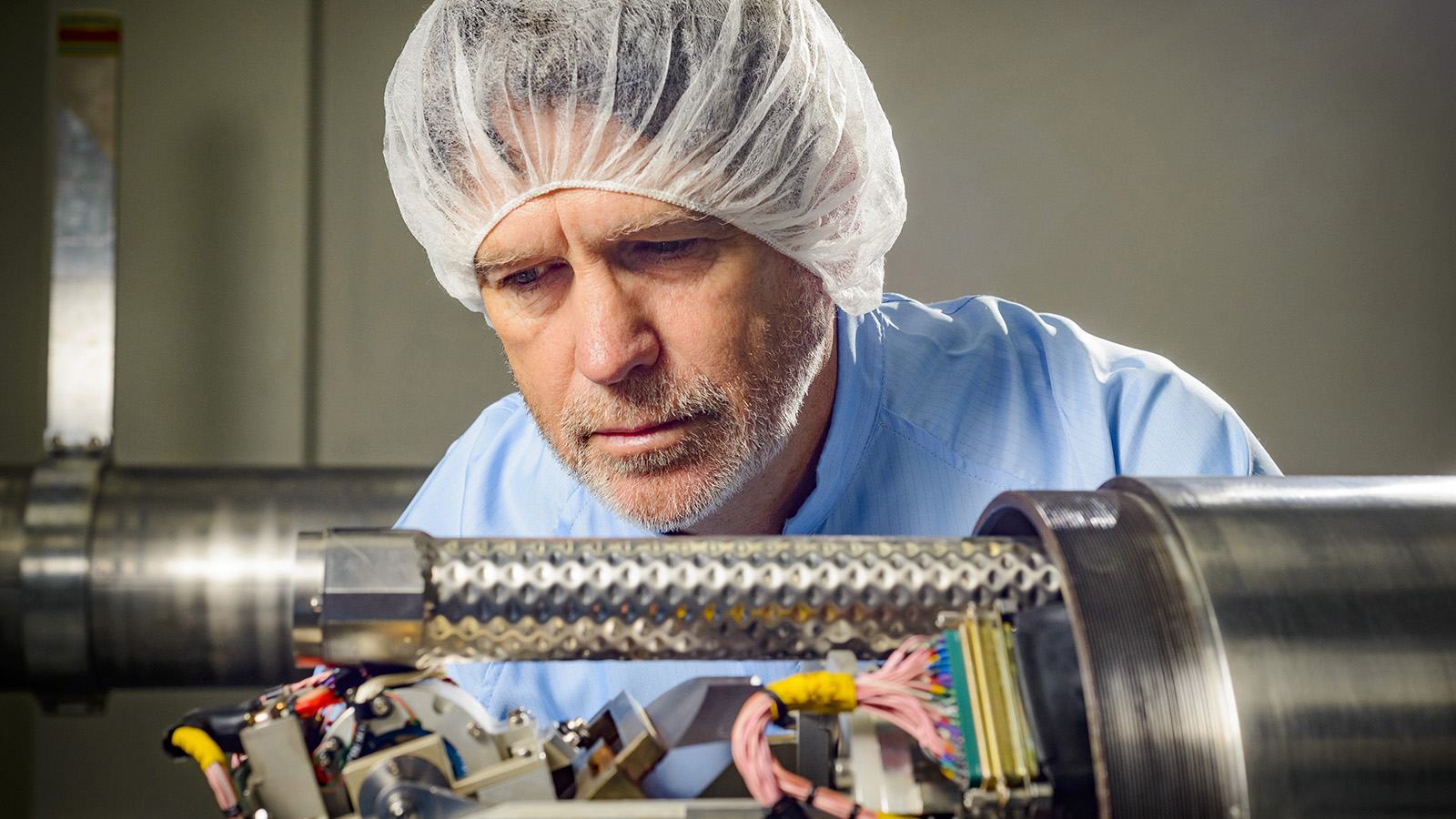 Technician working on periscope equipment in lab.