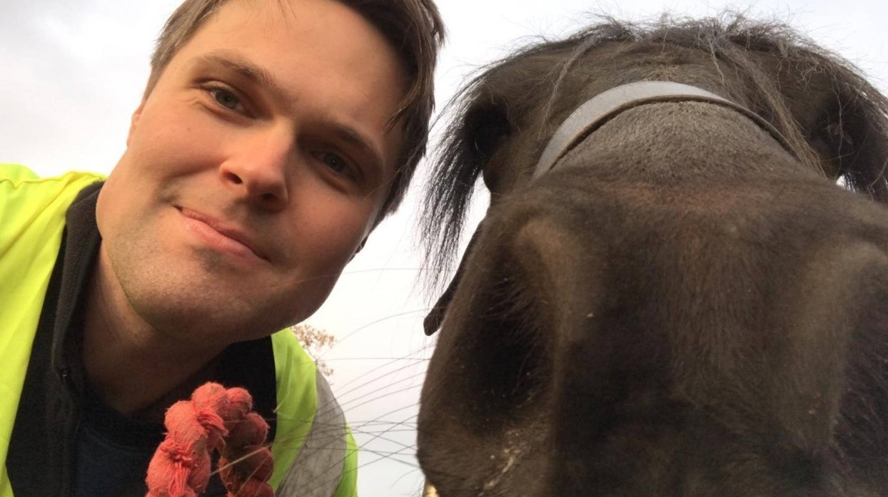 James takes selfie with a drak brown horse