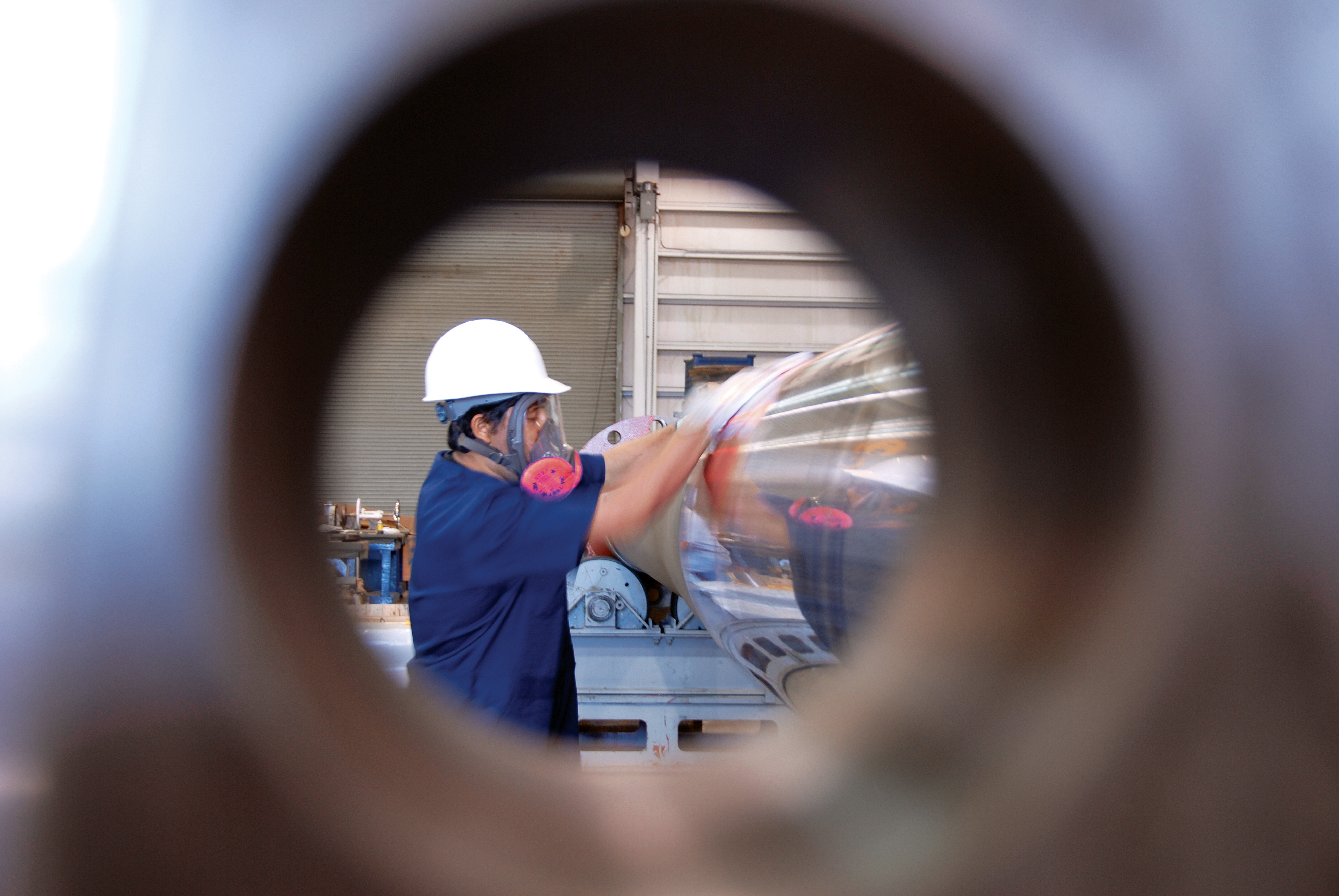A commercial ship repair employee viewed through a steel circle