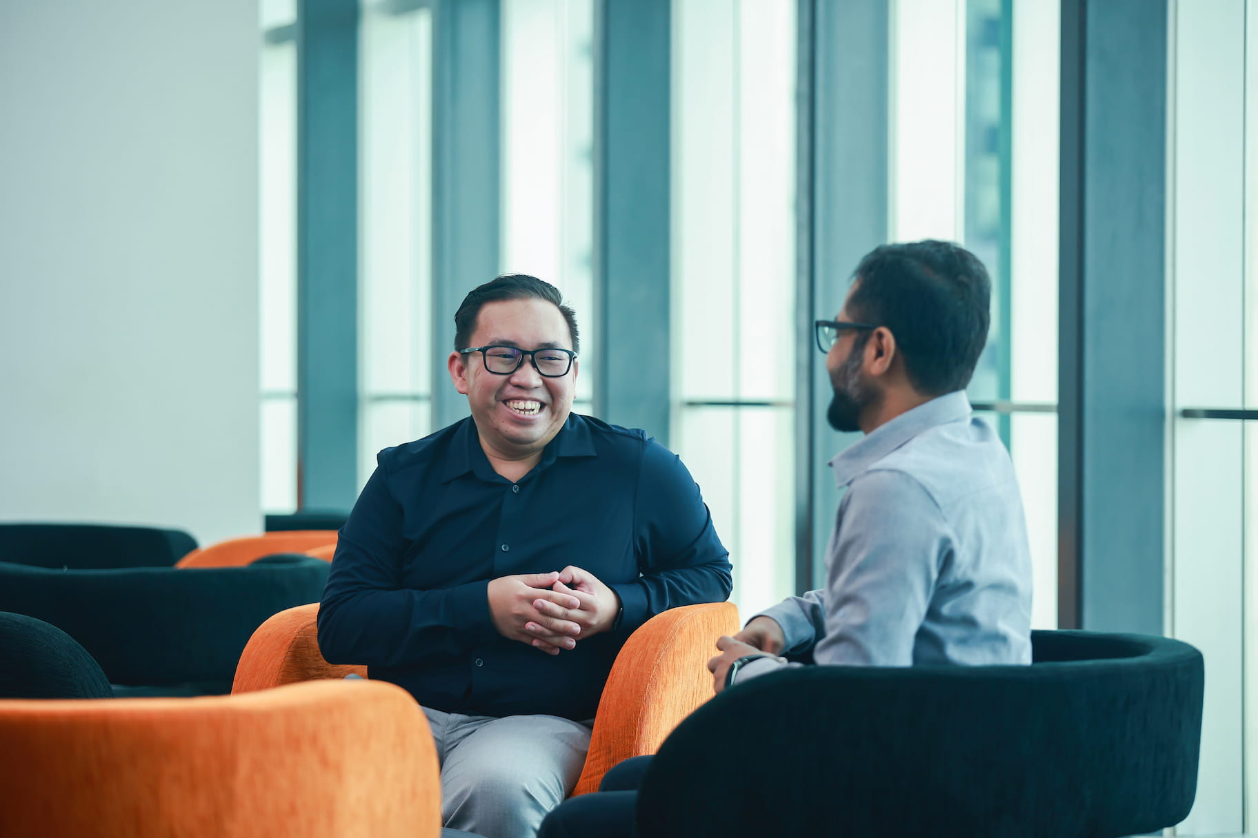 Two employees having a chat in colourful chairs