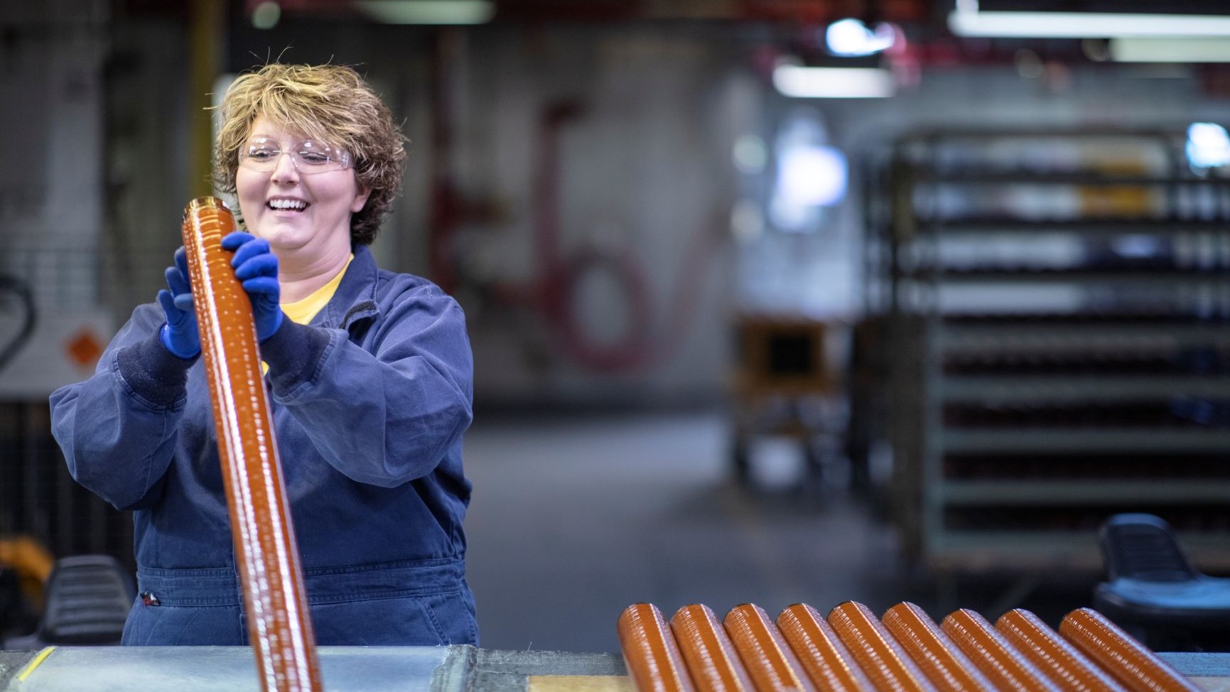 A BAE Systems employee at the Radford Army Ammunition Plant handles a Mk90 propellant grain.