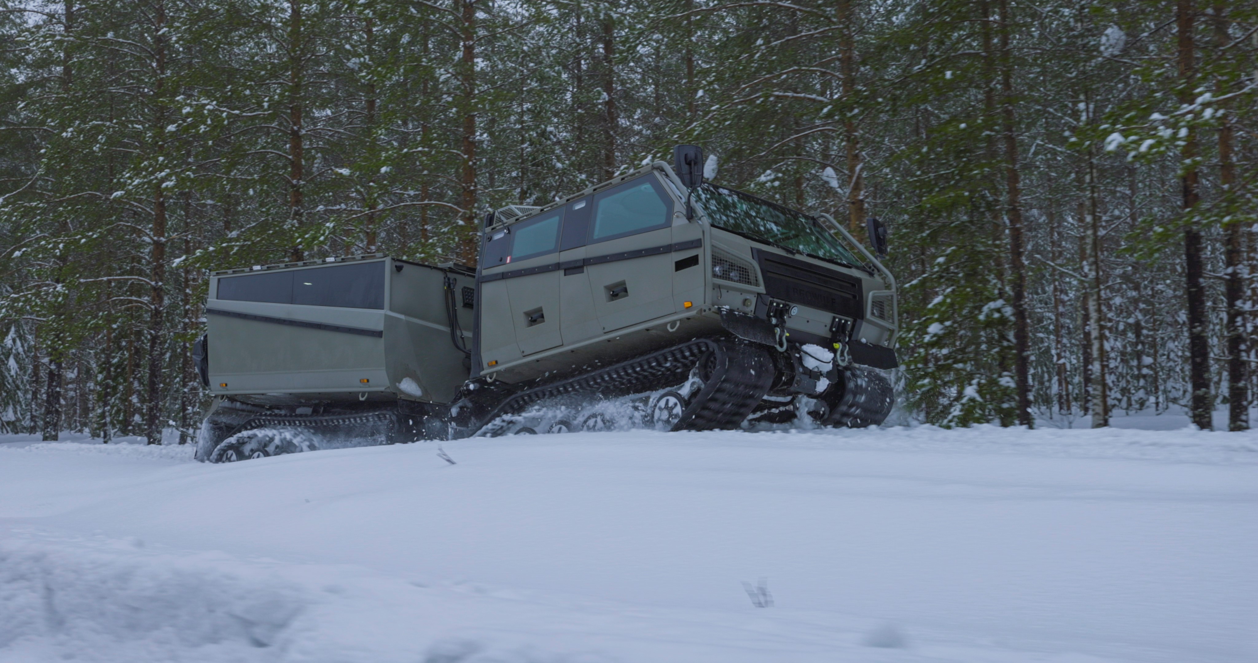 Beowulf vehicle driving through the snow in a forest