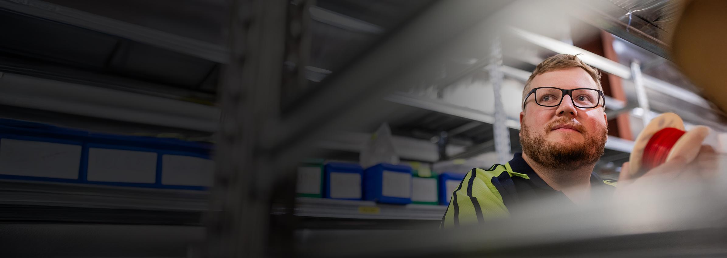 Employee holding wire thoughtfully