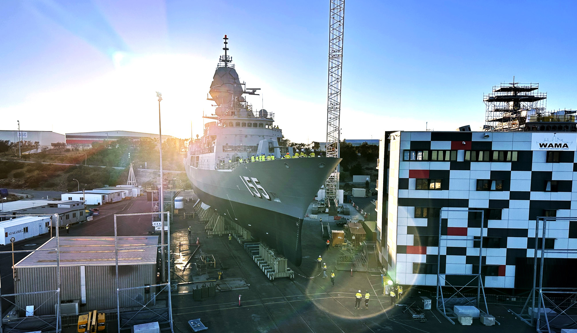 HMAS Ballarat (FFH 155) Anzac class frigate next to the WAMA building at sunrise