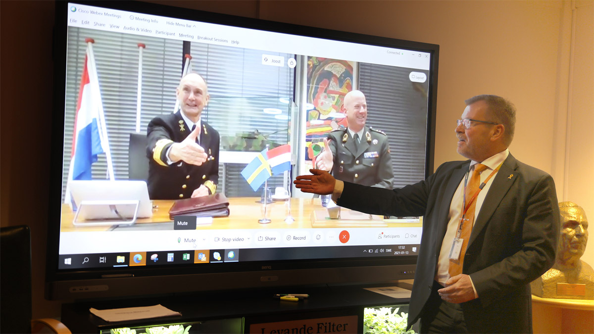 Admiral Arie Jan de Waard and Lieutenant General Martin Wijnen of the Royal Netherlands Army seal the deal via digital handshake with Tommy Gustafsson-Rask, managing director of BAE Systems Hägglunds.
