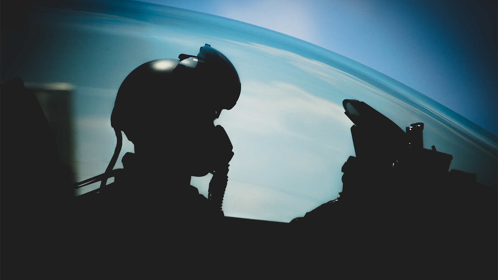 pilot with helmet on in aircraft