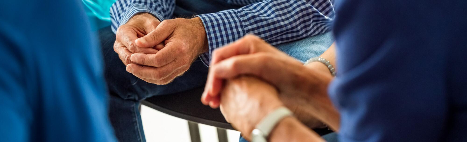 Close up of clasped hands in meeting